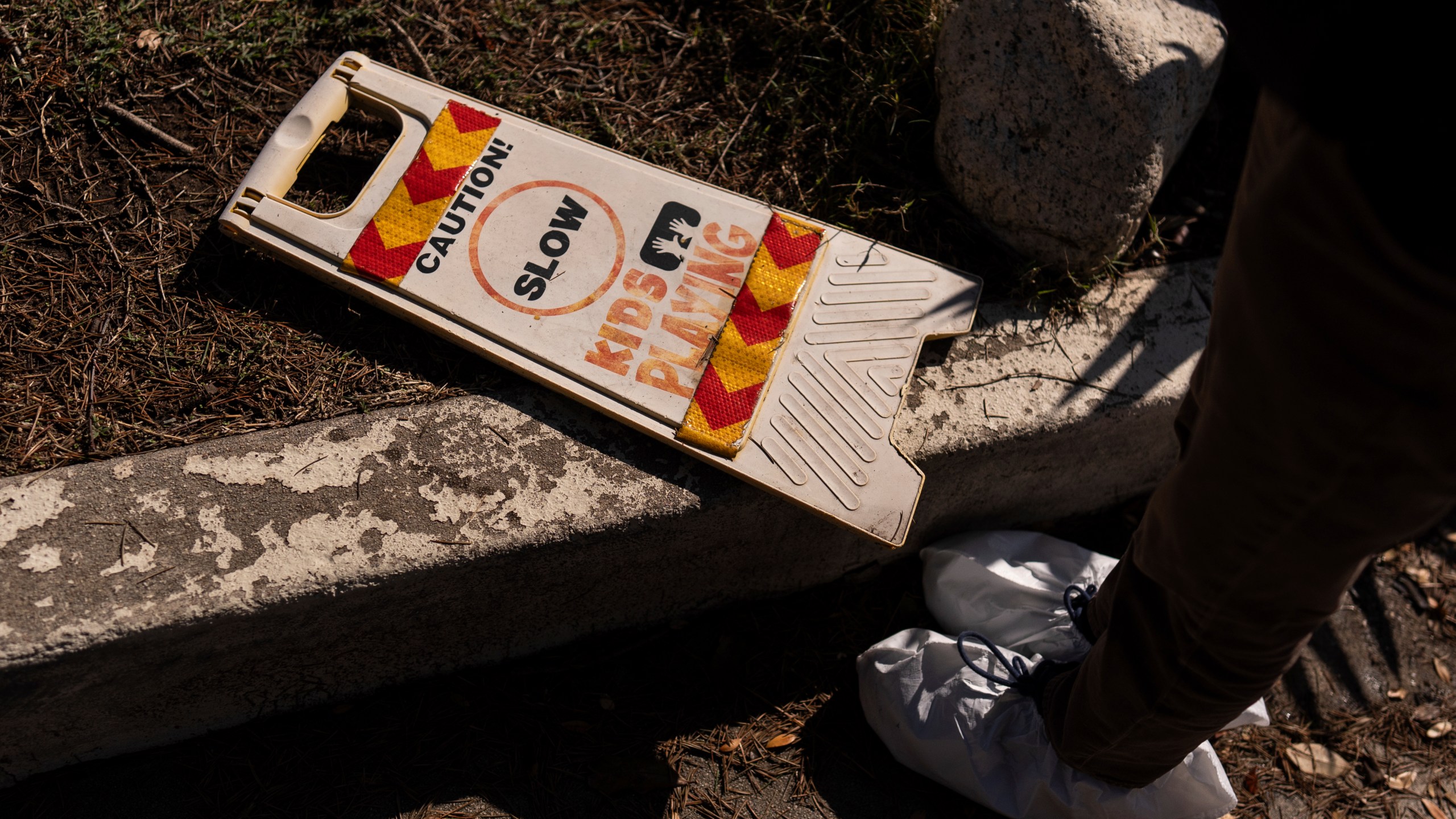 Ceiba Phillips, an 11-year-old Eaton Fire evacuee, looks at a safety sign at his best friend's home, which was gutted by the fire, during his first visit to his home and neighborhood since the fire in Altadena, Calif., Saturday, Feb. 8, 2025. (AP Photo/Jae C. Hong)