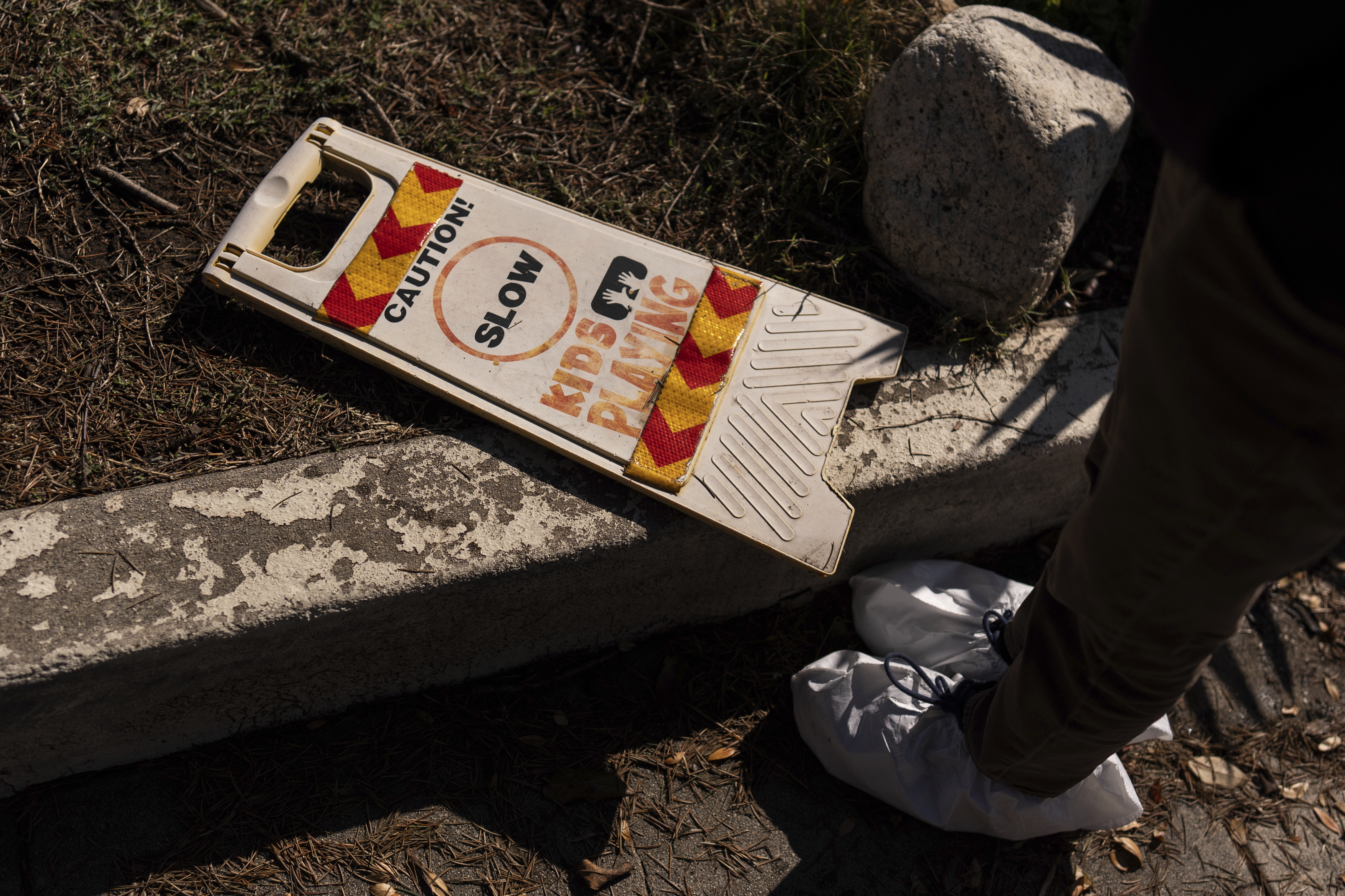 Ceiba Phillips, an 11-year-old Eaton Fire evacuee, looks at a safety sign at his best friend's home, which was gutted by the fire, during his first visit to his home and neighborhood since the fire in Altadena, Calif., Saturday, Feb. 8, 2025. (AP Photo/Jae C. Hong)