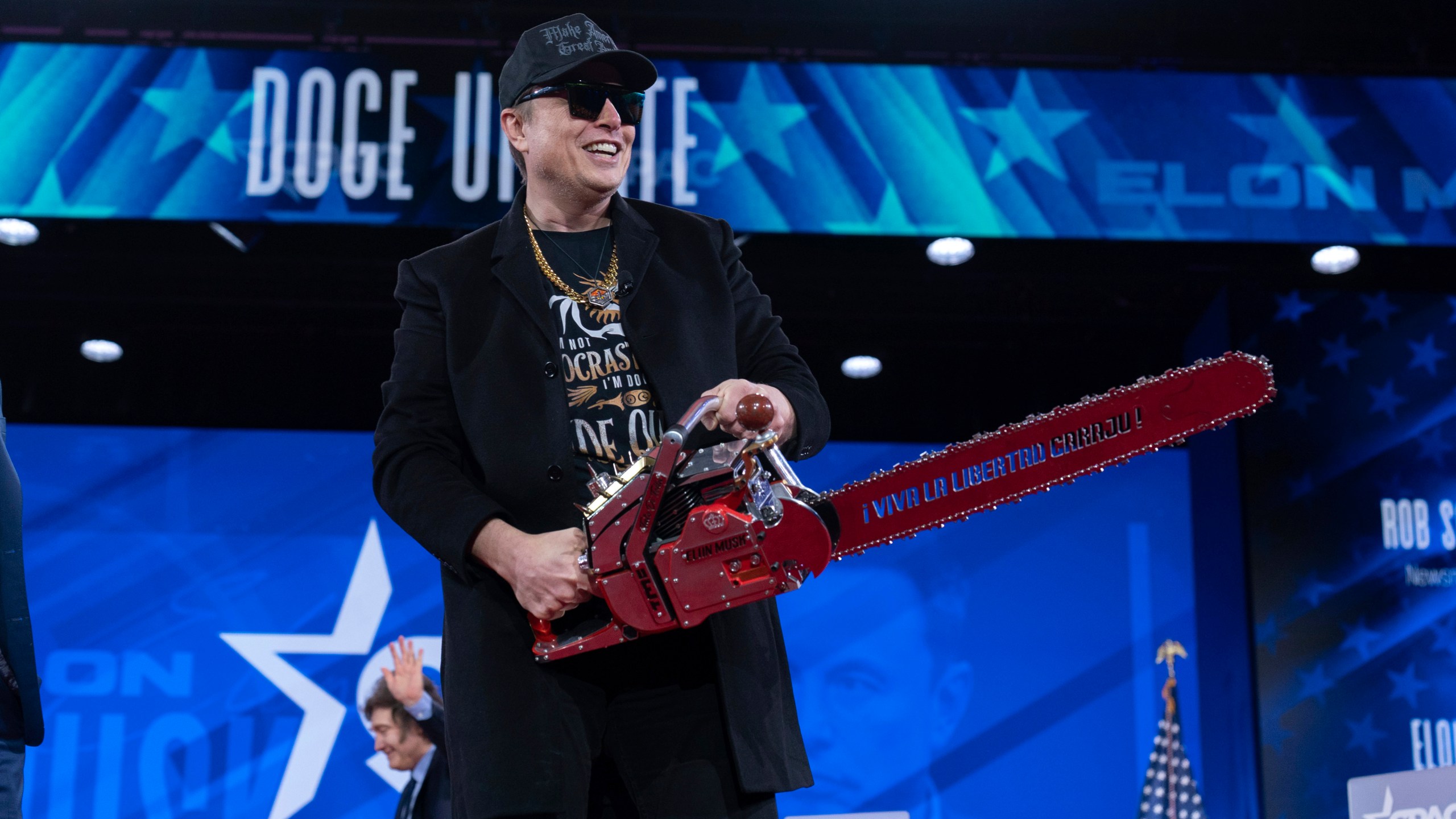 Elon Musk hold a chainsaw as he arrives to speak at the Conservative Political Action Conference, CPAC, at the Gaylord National Resort & Convention Center, Thursday, Feb. 20, 2025, in Oxon Hill, Md. (AP Photo/Jose Luis Magana)