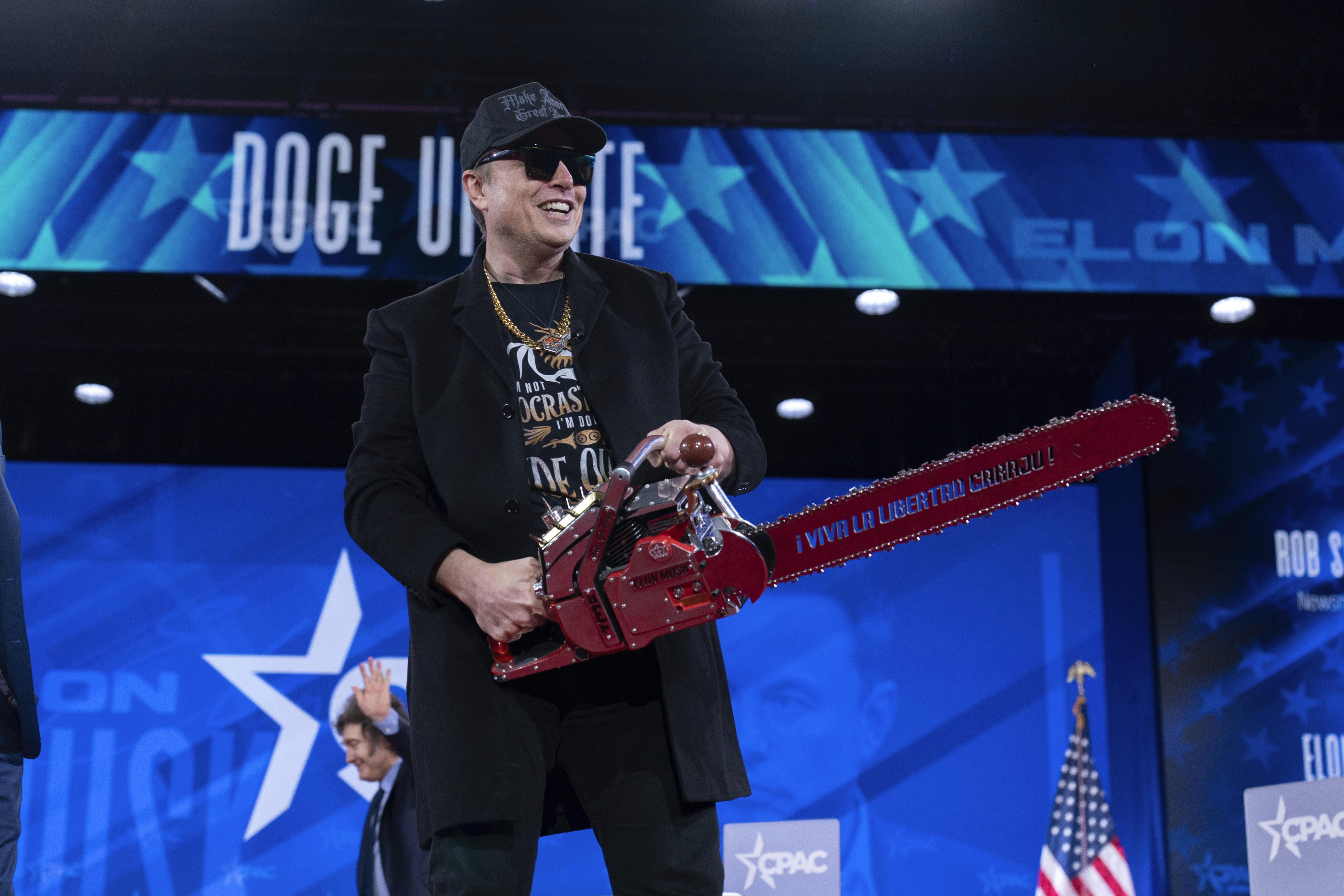 Elon Musk hold a chainsaw as he arrives to speak at the Conservative Political Action Conference, CPAC, at the Gaylord National Resort & Convention Center, Thursday, Feb. 20, 2025, in Oxon Hill, Md. (AP Photo/Jose Luis Magana)