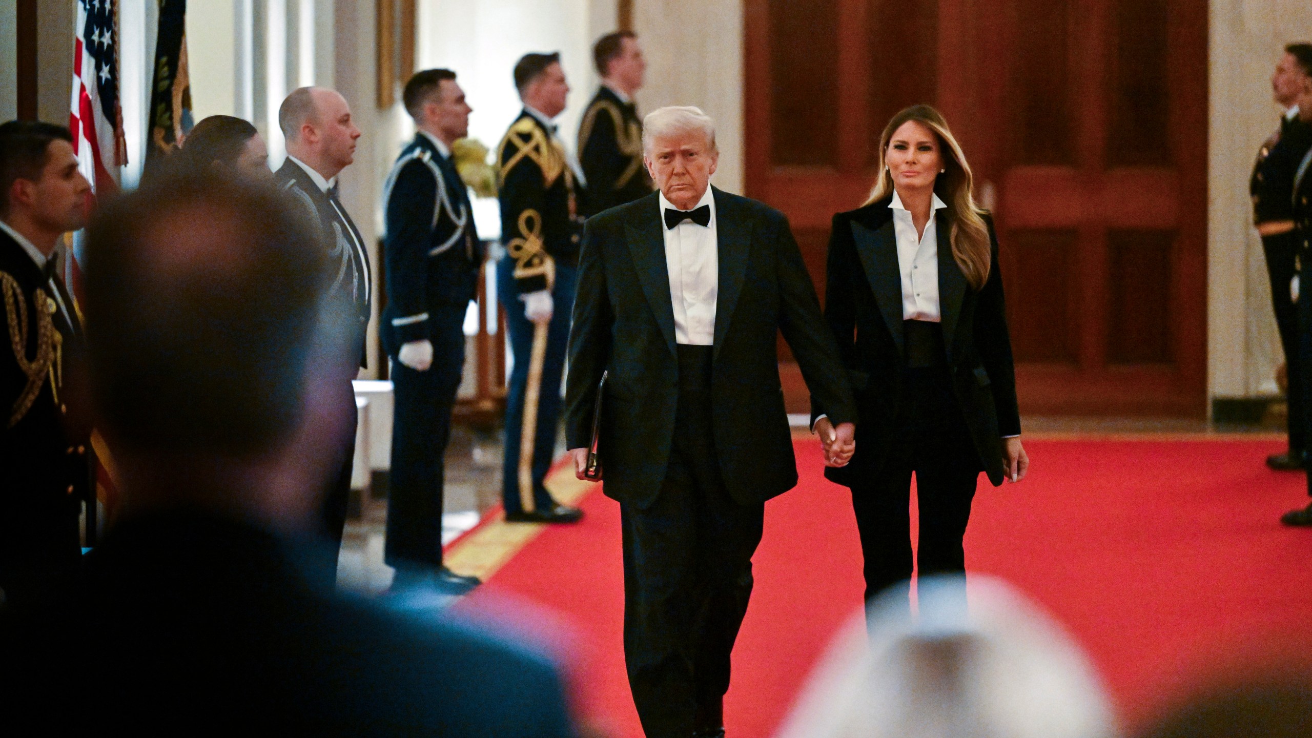 President Donald Trump and first lady Melania Trump arrive at the National Governors Association dinner and reception in the East Room of the White House Saturday, Feb. 22, 2025, in Washington. (Pool via AP)