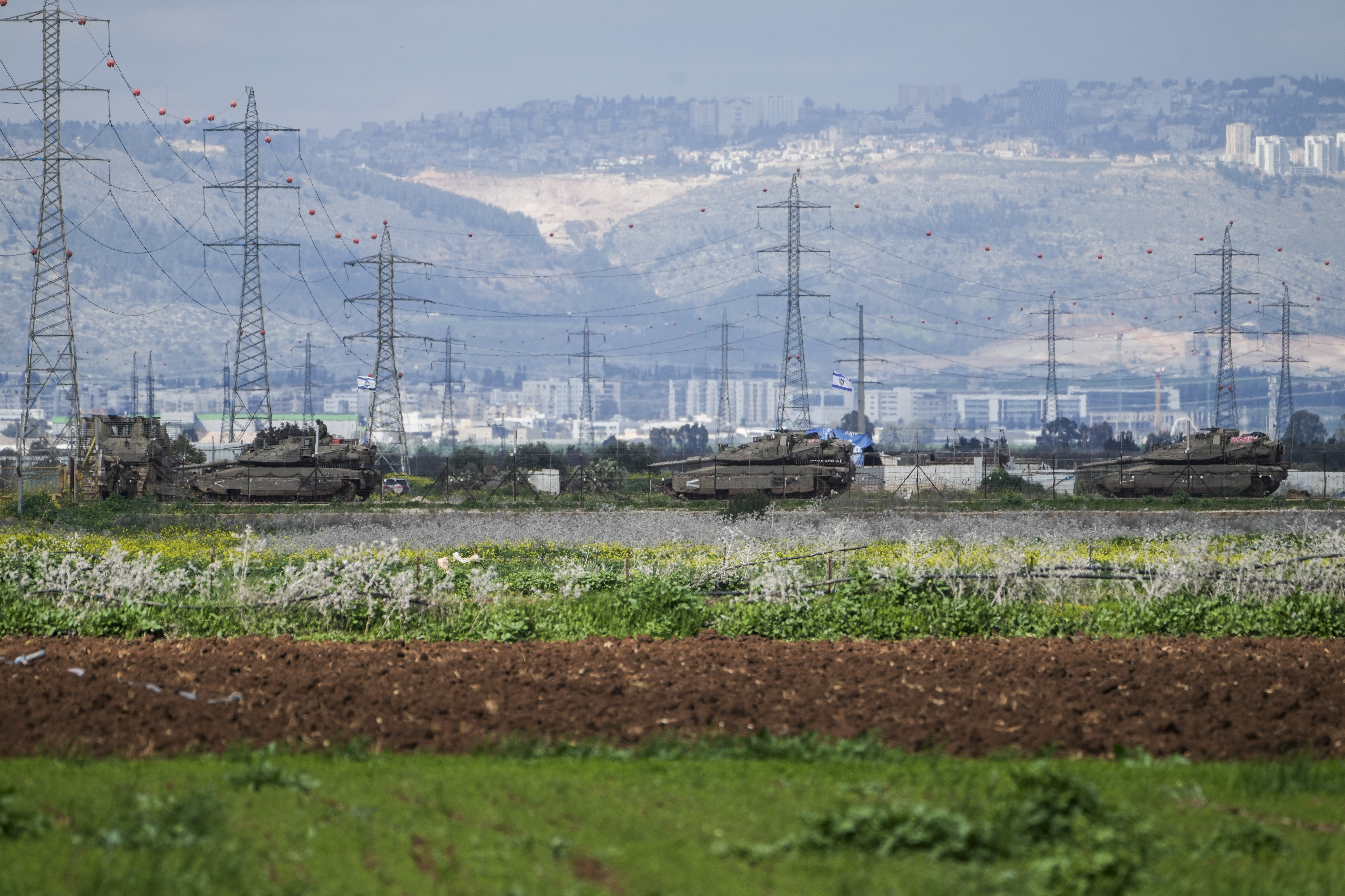 Israeli tanks gather outside of the occupied West Bank near Jenin, Sunday, Feb. 23, 2025. (AP Photo/Majdi Mohammed)