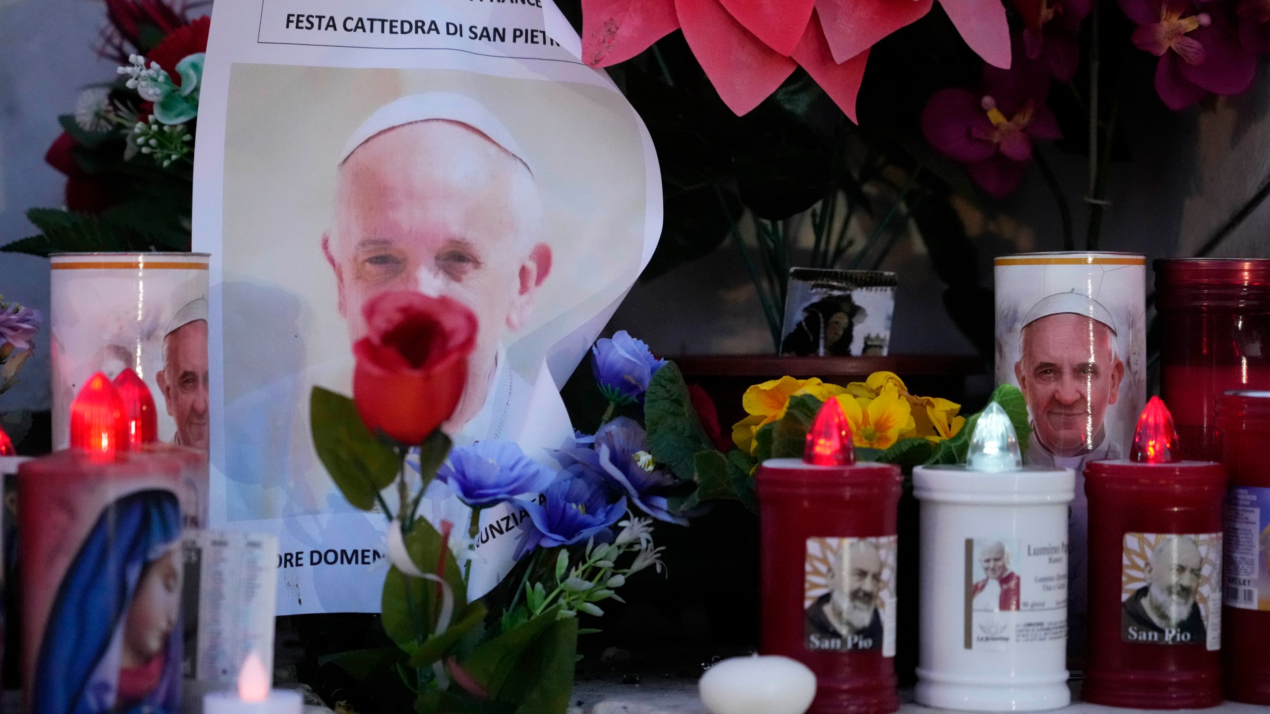 Candles are seen near pictures of Pope Francis outside the Agostino Gemelli Polyclinic in Rome, Sunday, Feb. 23, 2025, where the Pontiff is hospitalized since Feb. 14. (AP Photo/Gregorio Borgia)