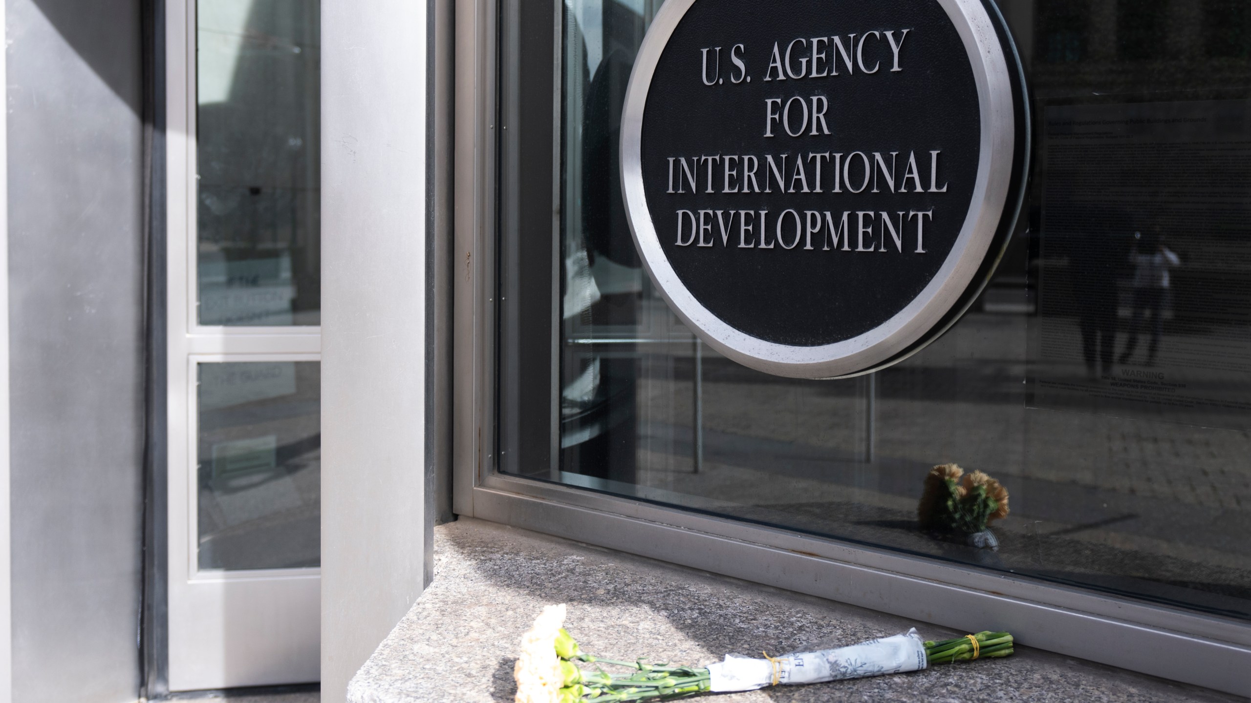 A bouquet of white flowers placed outside the headquarters of the United States Agency for International Development, or USAID, is pictured, Friday, Feb. 7, 2025, in Washington. (AP Photo/Manuel Balce Ceneta)