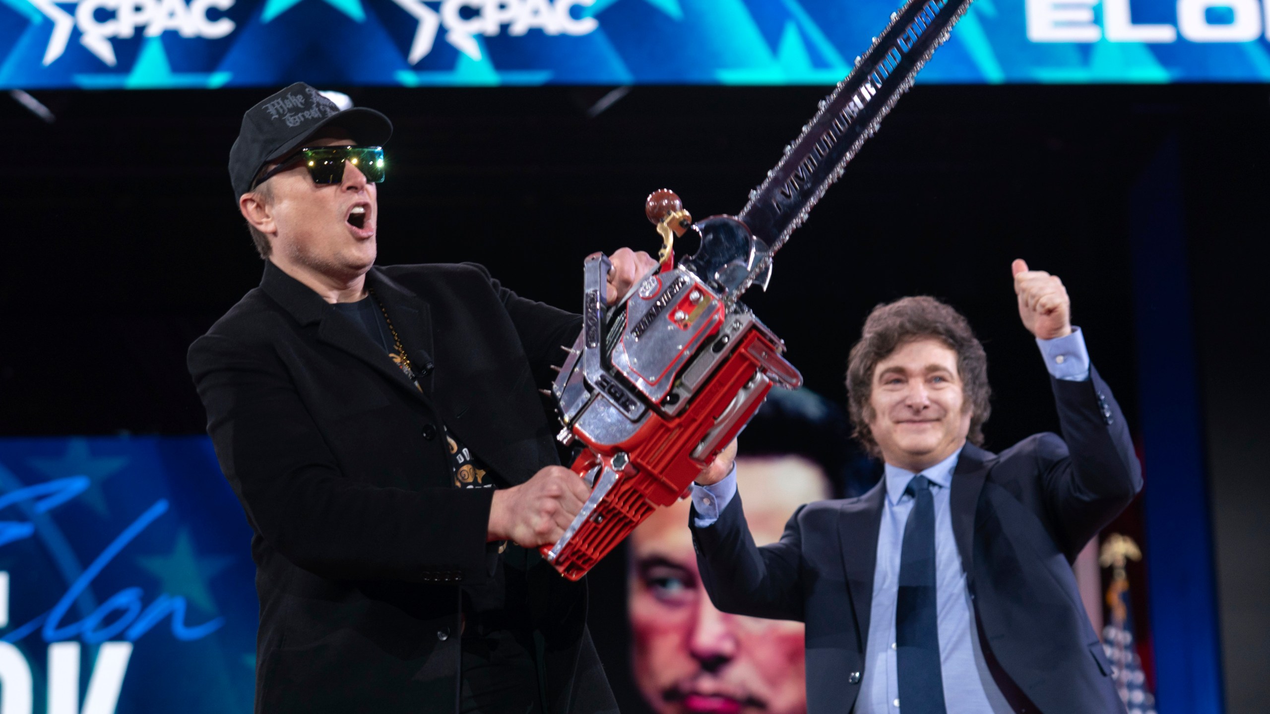 Elon Musk, left, receives a chainsaw from Argentina's President Javier Milei as they arrive speaks at the Conservative Political Action Conference, CPAC, at the Gaylord National Resort & Convention Center, Thursday, Feb. 20, 2025, in Oxon Hill, Md. (AP Photo/Jose Luis Magana)