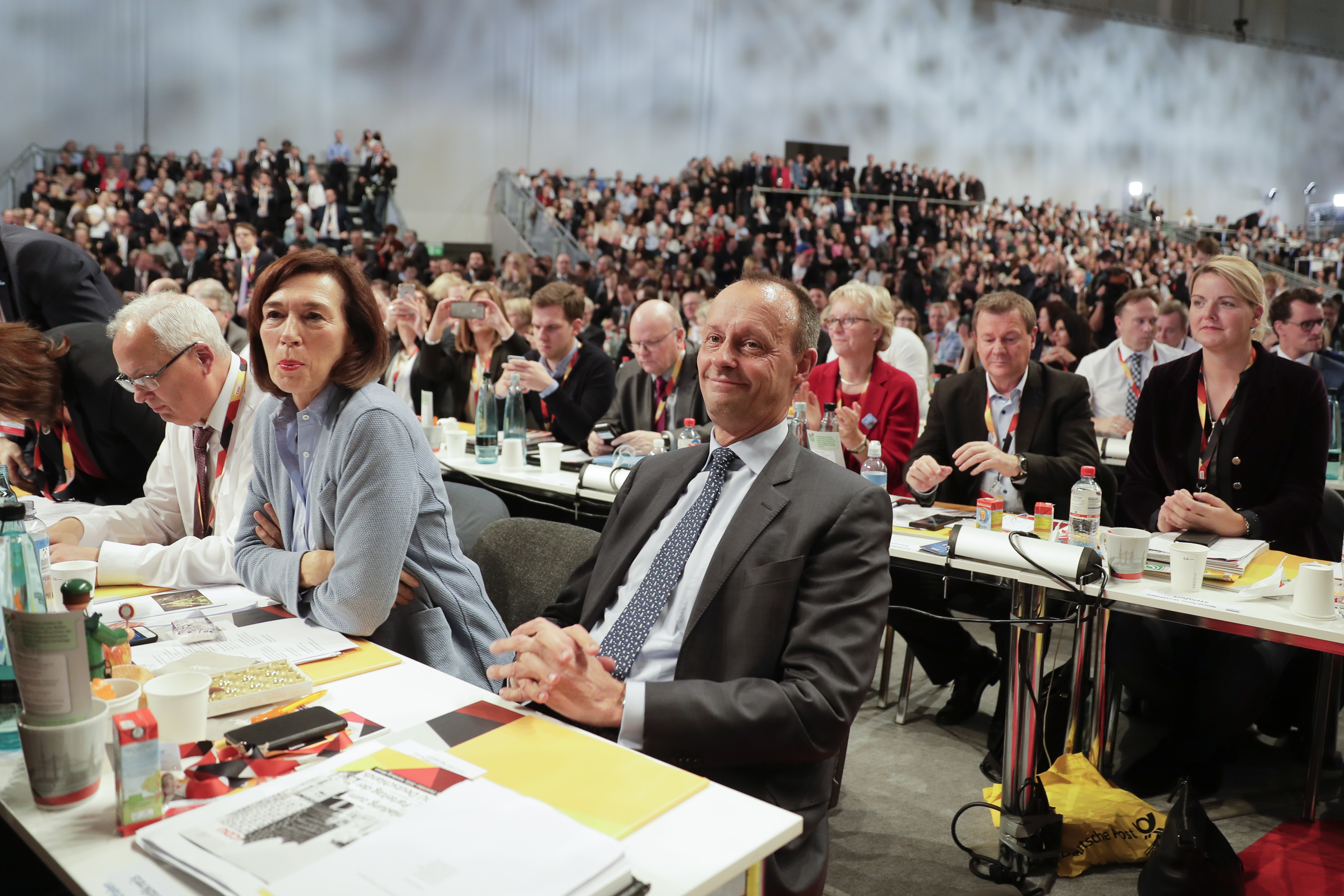 FILE - Friedrich Merz, center, party member and candidate for the party chairmanship, smiles after his speech during a party convention of the Christian Democratic Union party (CDU) in Hamburg, Germany, Dec. 7, 2018. (AP Photo/Markus Schreiber, File)