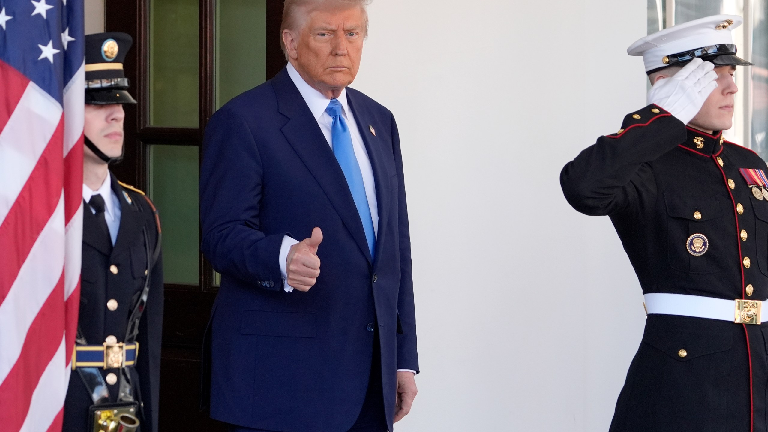 President Donald Trump gives a thumbs-up as he waits to greet France's President Emmanuel Macron before a news conference at the White House, Monday, Feb. 24, 2025, in Washington. (AP Photo/Manuel Balce Ceneta)