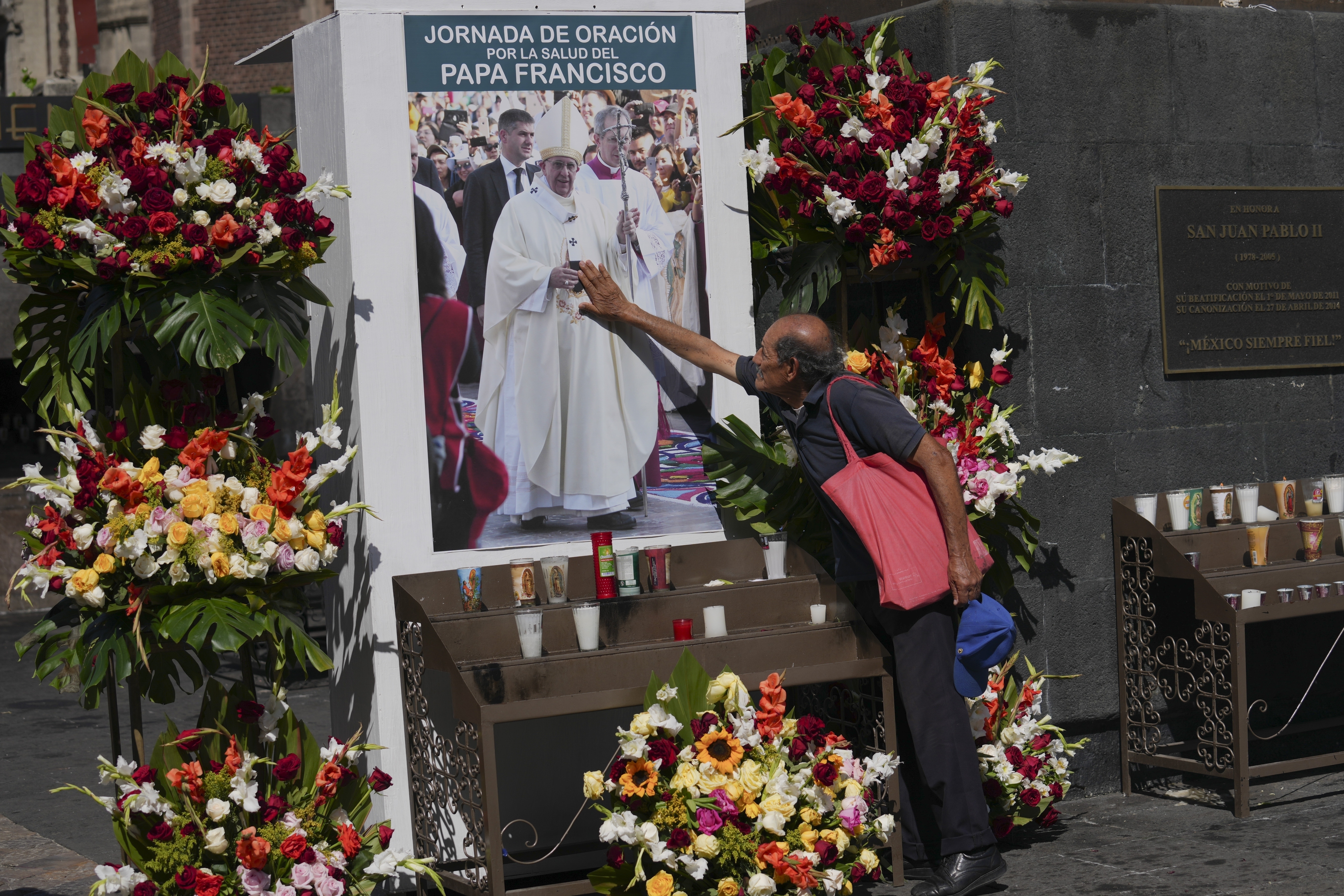 A parishioner touches an image of Pope Francis during a prayer service for his health outside of the Basilica of Guadalupe in Mexico City, Monday, Feb. 24, 2025. (AP Photo/Marco Ugarte)