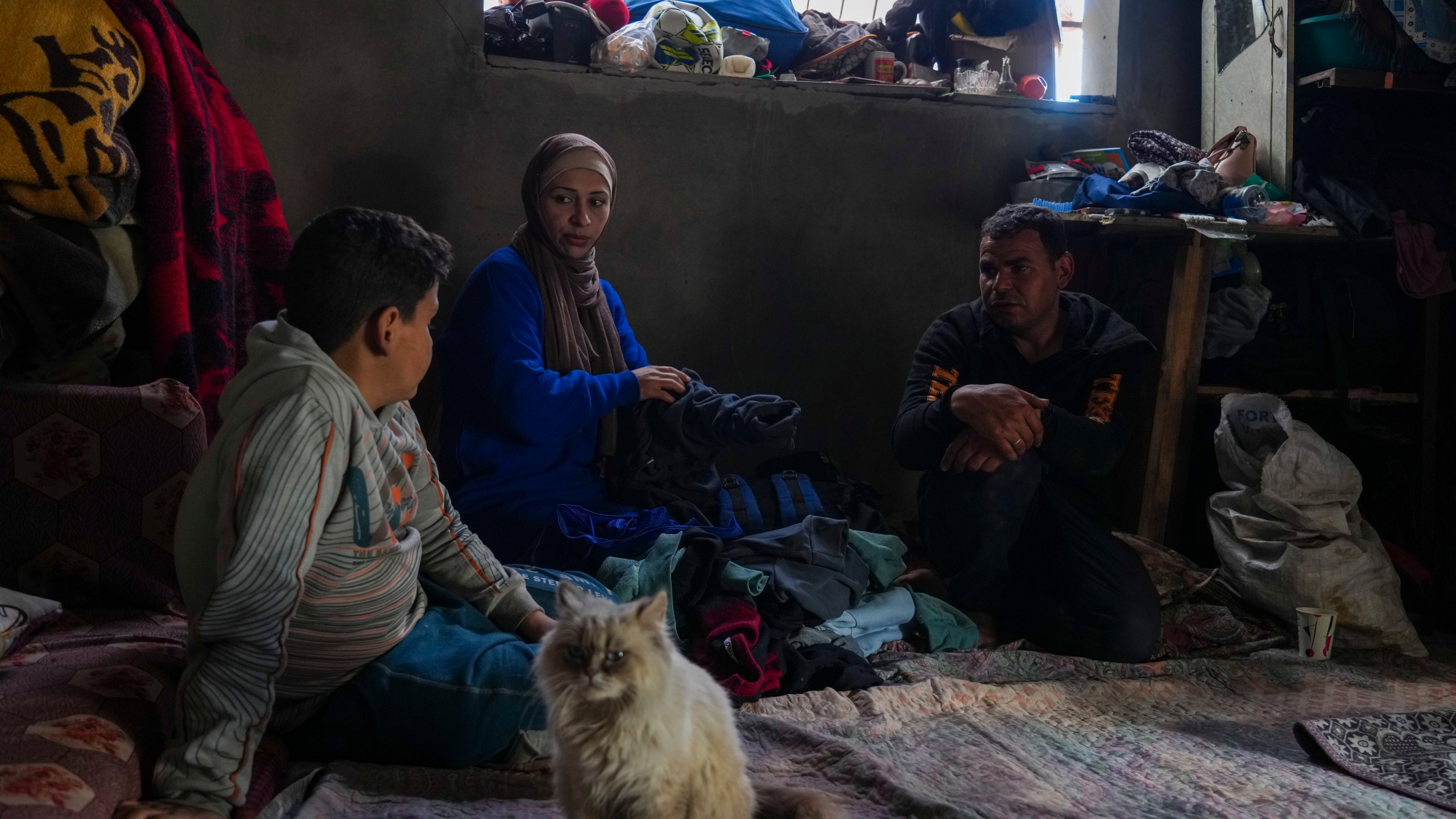 Members of the Tambora family sit in their home, which was struck by an Israeli airstrike on Oct. 20, 2023, in Beit Lahiya, northern Gaza Strip, Friday, Feb. 21, 2025. (AP Photo/Abdel Kareem Hana)