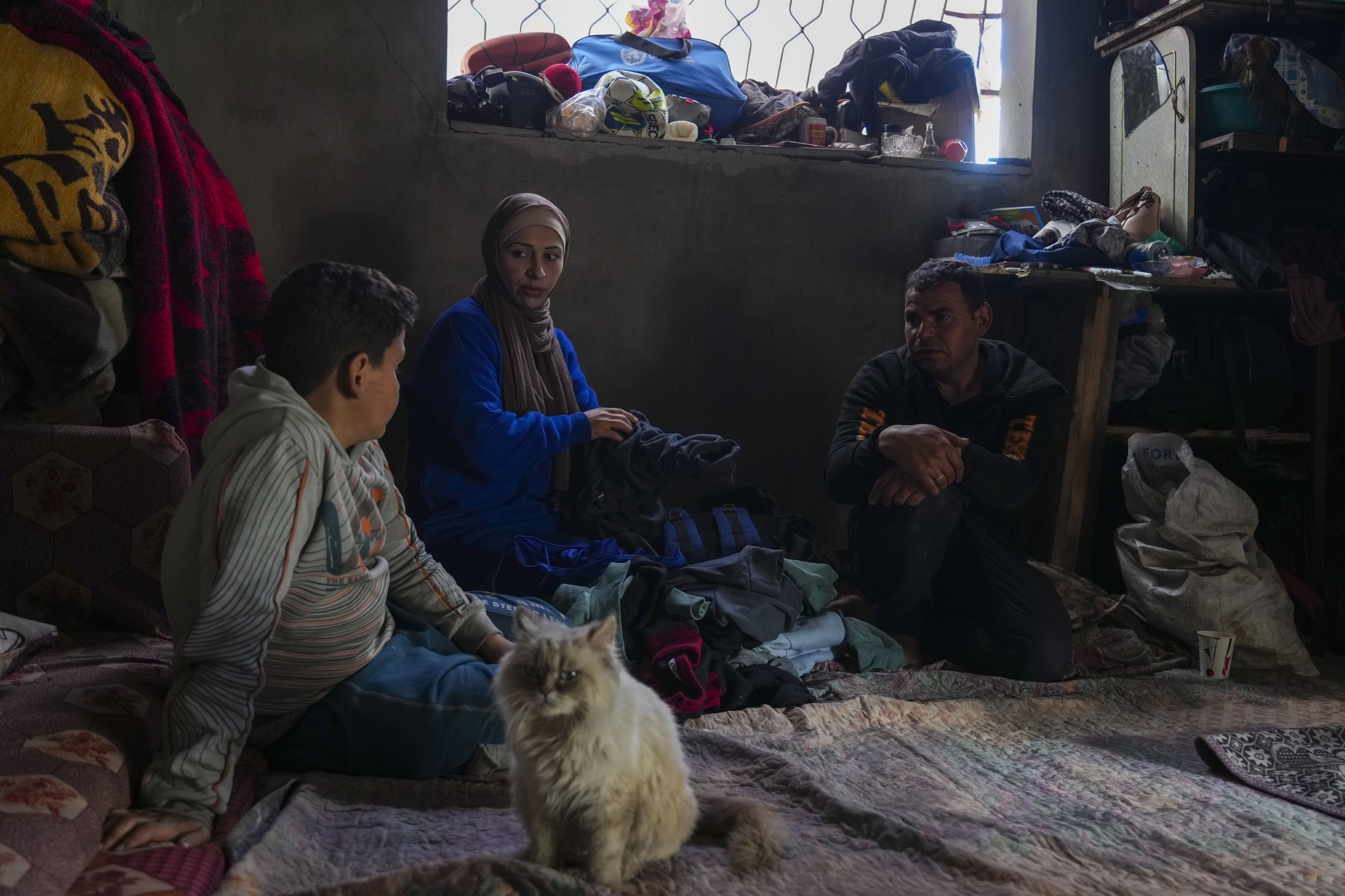 Members of the Tambora family sit in their home, which was struck by an Israeli airstrike on Oct. 20, 2023, in Beit Lahiya, northern Gaza Strip, Friday, Feb. 21, 2025. (AP Photo/Abdel Kareem Hana)