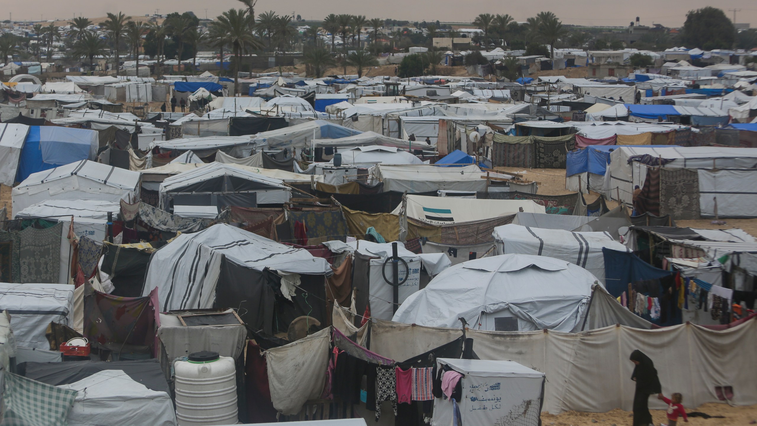 Palestinians displaced by the Israeli air and ground offensive on the Gaza Strip walk through a makeshift tent camp in Muwasi, Rafah, southern Gaza, Monday, Feb. 24, 2025. (AP Photo/Jehad Alshrafi)