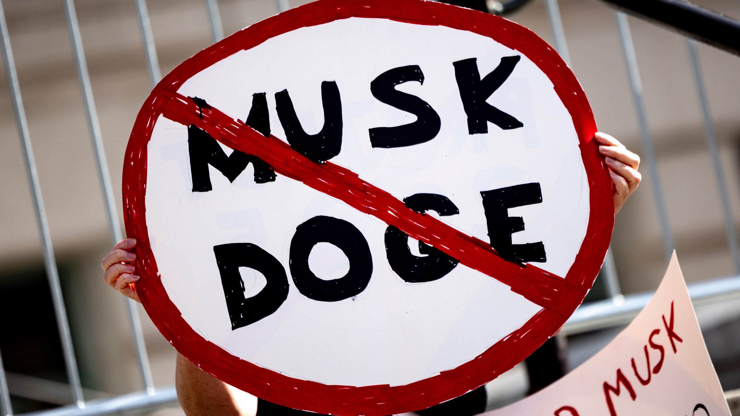 A demonstrator holds a sign during a rally to protest President Donald Trump and Elon Musk policies Feb. 17, 2025, in Los Angeles. (AP Photo/Etienne Laurent, File)