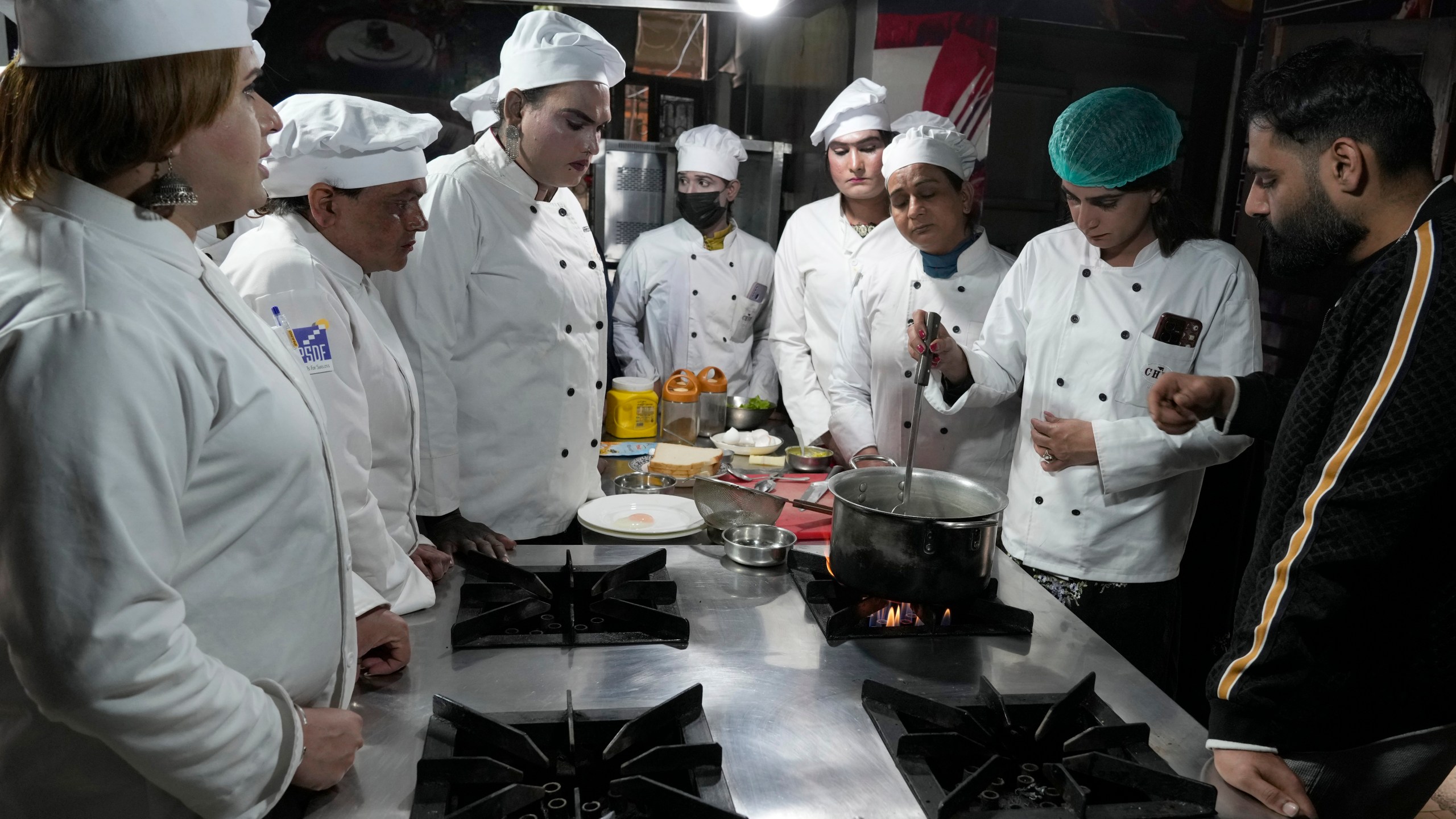 Chef Ali Haider, right, teaches transgender persons during their cooking class at the Culinary & Hotel Institute of Pakistan, in Lahore, Pakistan, Tuesday, Feb. 25, 2025. (AP Photo/K.M Chaudary)