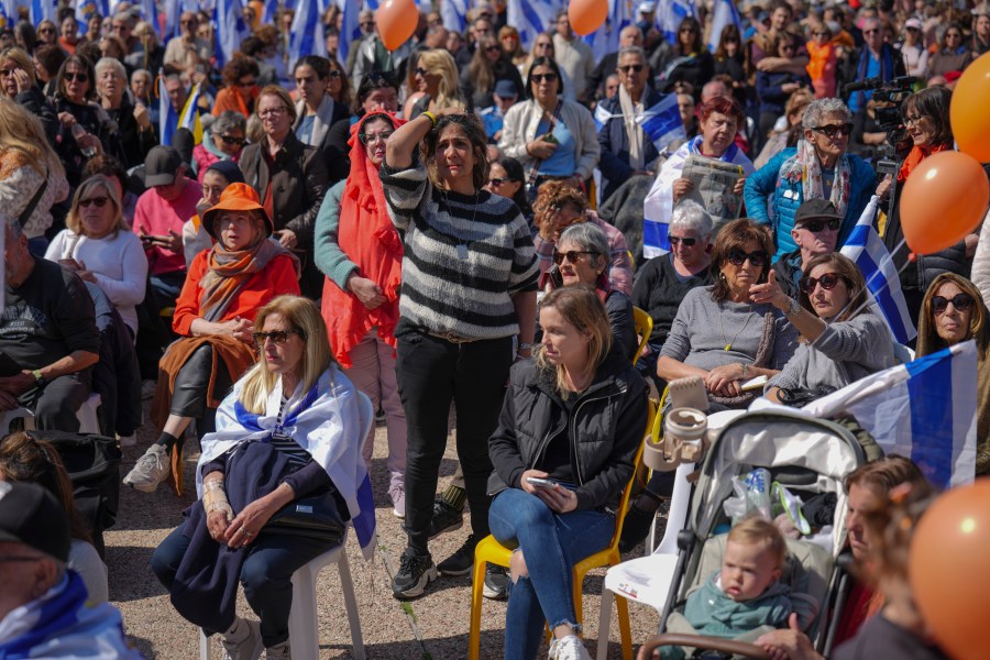 People watch a live broadcast from the funeral of slain hostages Shiri Bibas and her two children, Ariel and Kfir, at a plaza known as the Hostages Square in Tel Aviv, Israel, Wednesday, Feb. 26, 2025. The mother and her two children were abducted by Hamas on Oct. 7, 2023, and their remains were returned from Gaza to Israel last week as part of a ceasefire agreement with Hamas. (AP Photo/Ariel Schalit)