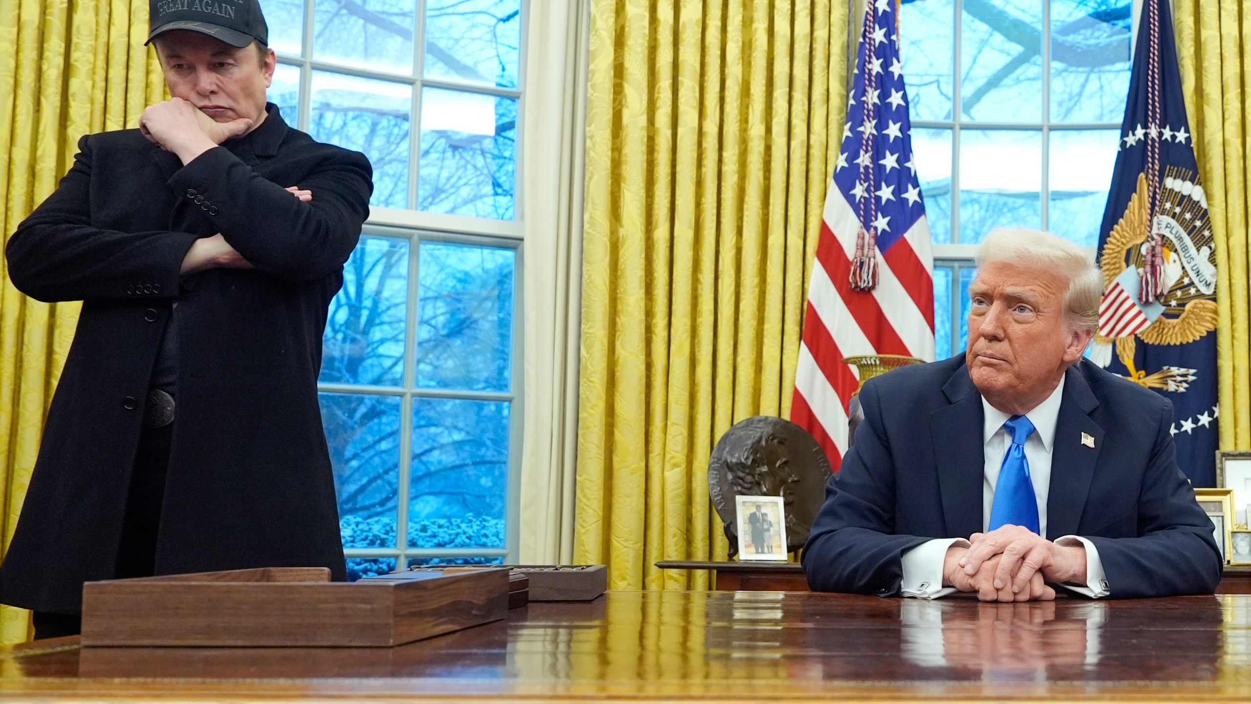 Elon Musk listens as President Donald Trump speaks with reporters in the Oval Office at the White House, Tuesday, Feb. 11, 2025, in Washington. (AP Photo/Alex Brandon)