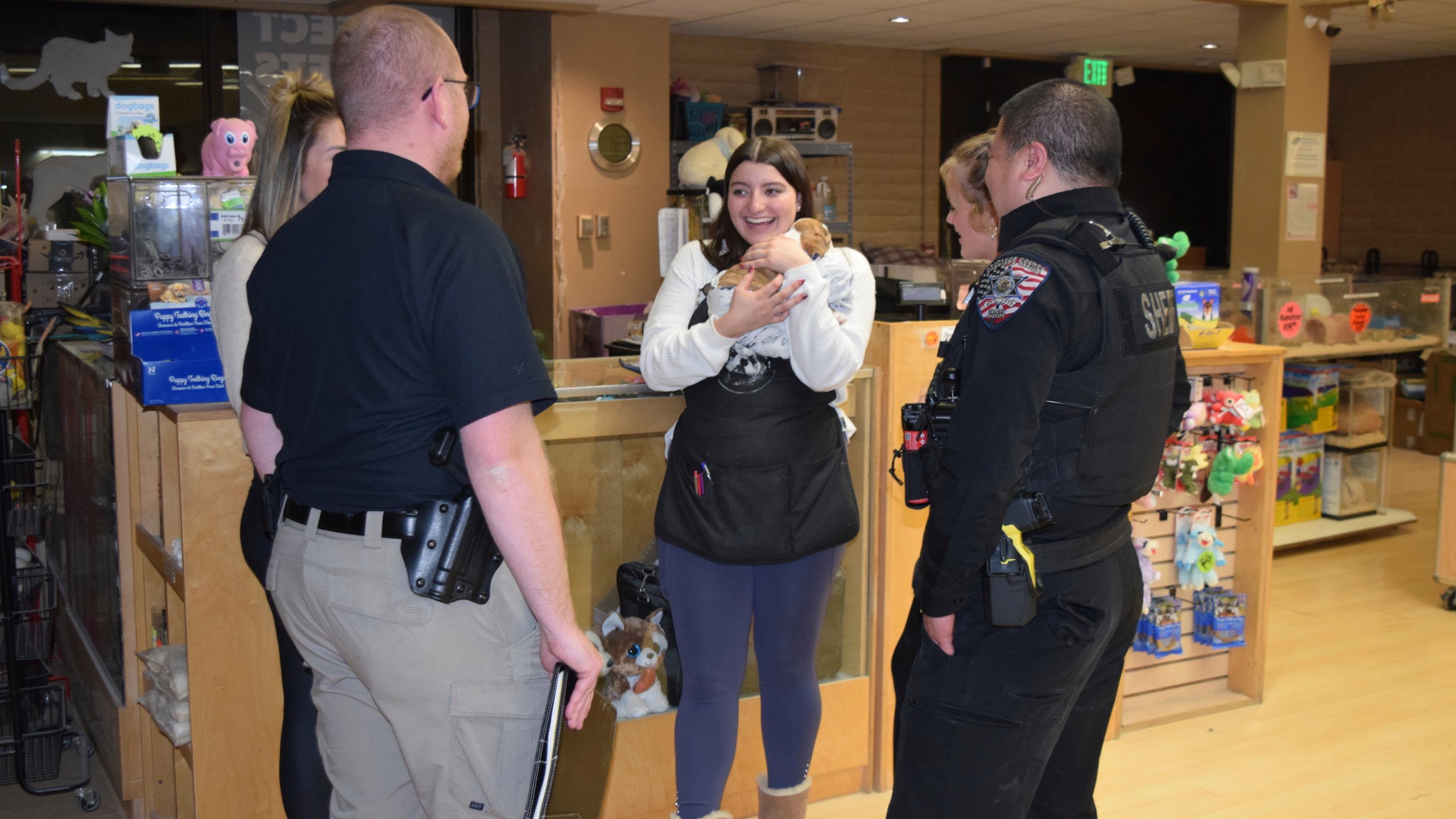 In this photo released by the Arapahoe County Sheriff’s Office, a Perfect Pets worker holds one of two bulldog puppies stolen from the store, after the dogs were returned by a person who bought the dogs from a street vendor, in Centennial, Colorado, Monday, Feb. 24, 2025. (Arapahoe County Sheriff’s Office via AP)