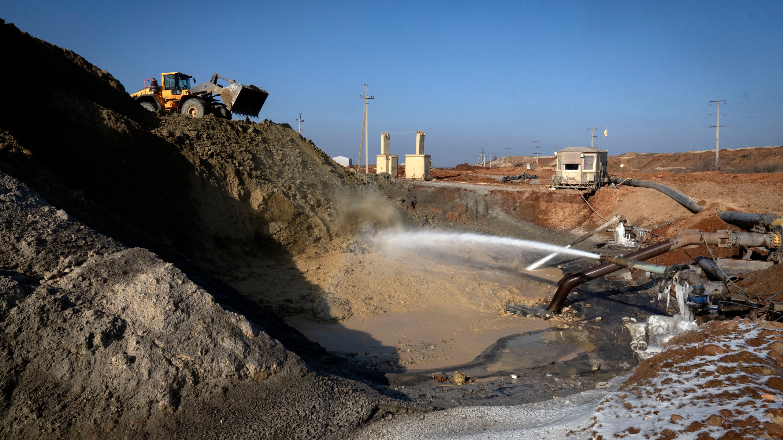 FILE- Miners extract ilmenite, a key element used to produce titanium, at an open pit mine in the central region of Kirovohrad, Ukraine, Feb. 12, 2025. (AP Photo/Efrem Lukatsky, File)