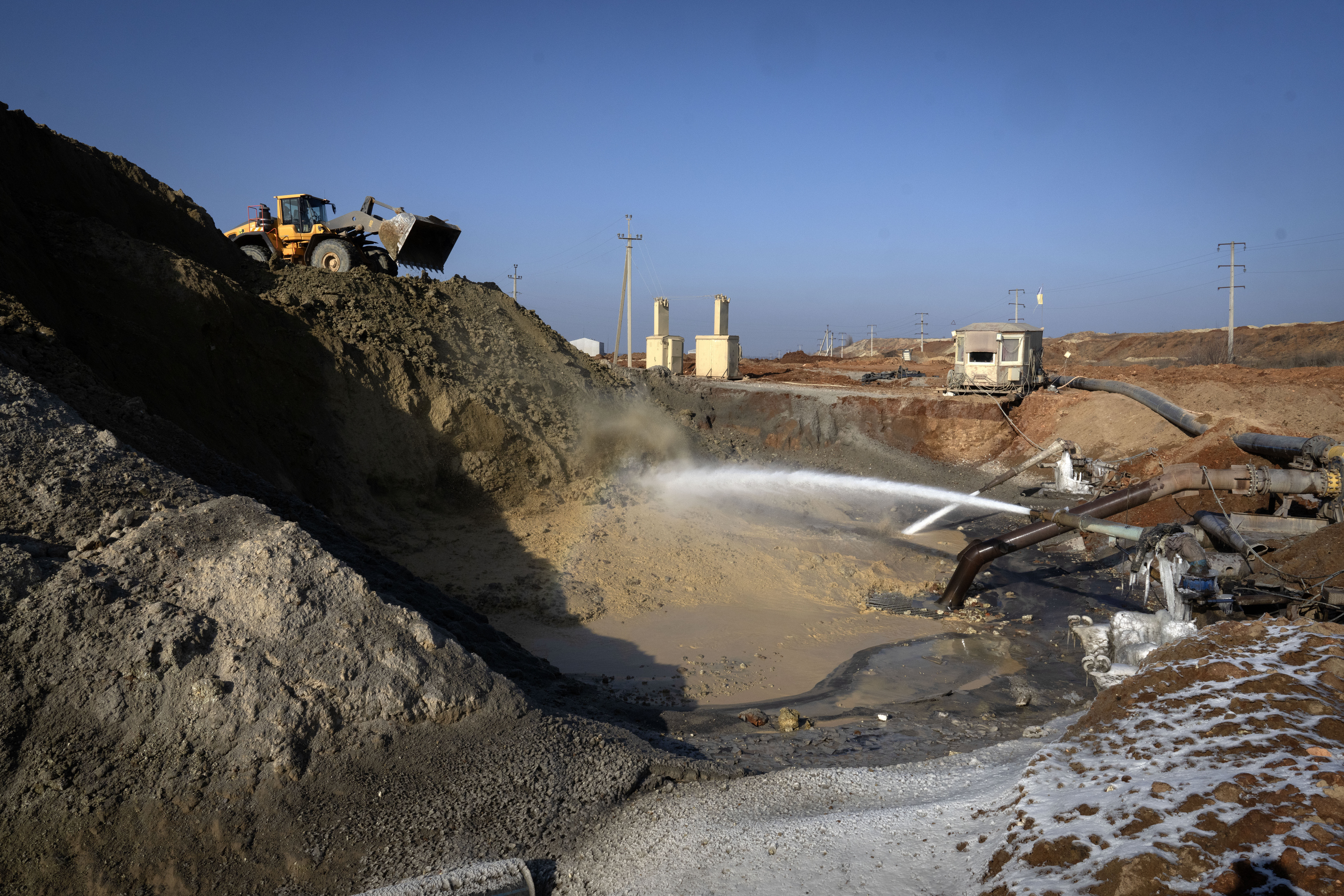 FILE- Miners extract ilmenite, a key element used to produce titanium, at an open pit mine in the central region of Kirovohrad, Ukraine, Feb. 12, 2025. (AP Photo/Efrem Lukatsky, File)