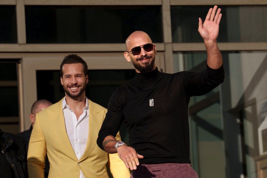 FILE - Andrew Tate waves as he exits the Bucharest Tribunal with his brother Tristan, in Bucharest, Romania, Thursday, Jan. 9, 2025. (AP Photo/Vadim Ghirda, File)