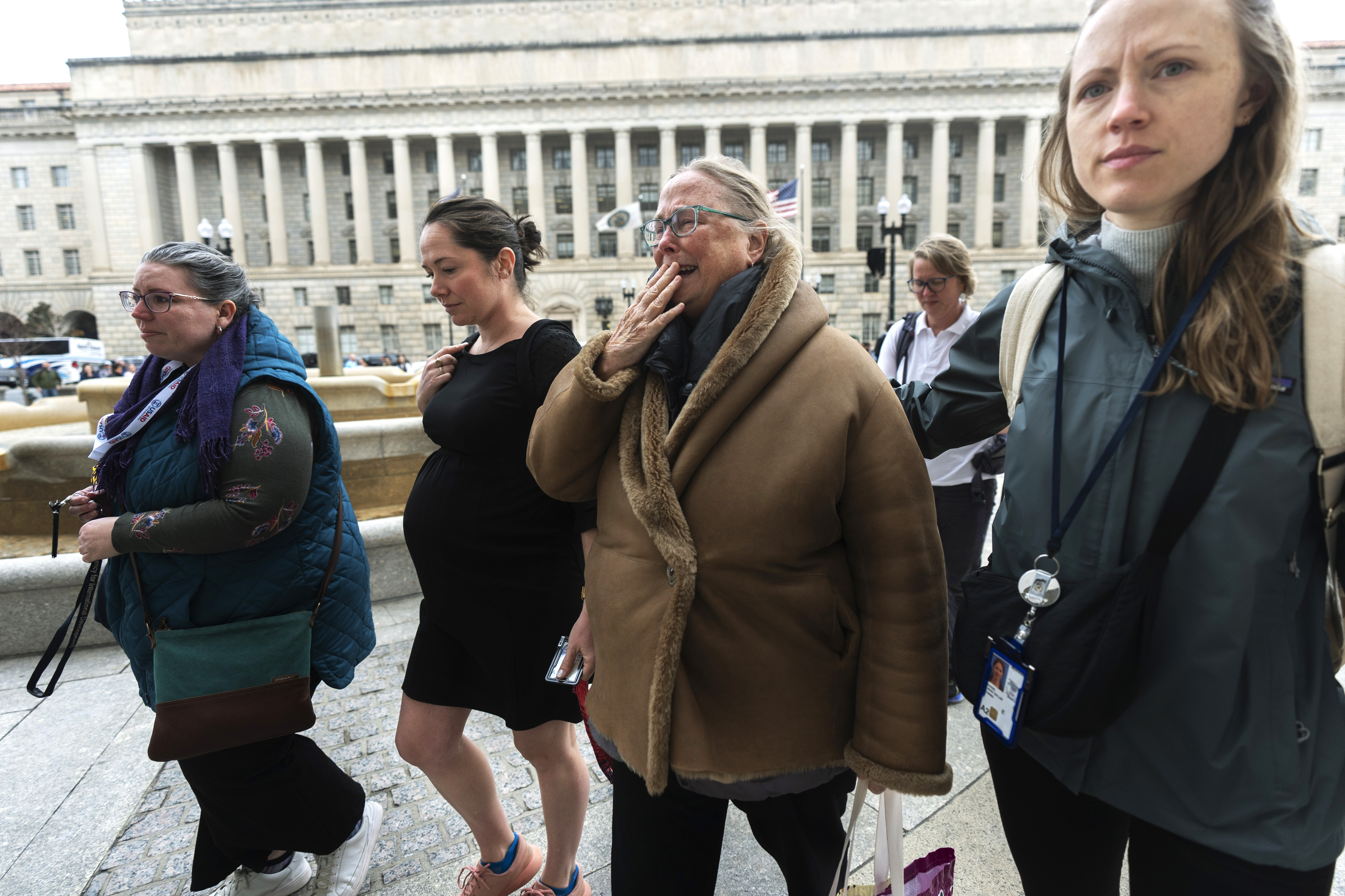 Lucy Mize, second from right, a United States Agency for International Development (USAID) health officer for 31 years, cries as she walks with fellow USAID workers to the USAID headquarters in Washington, to gather personal belongings, Thursday, Feb. 27, 2025, in Washington. (AP Photo/Manuel Balce Ceneta)