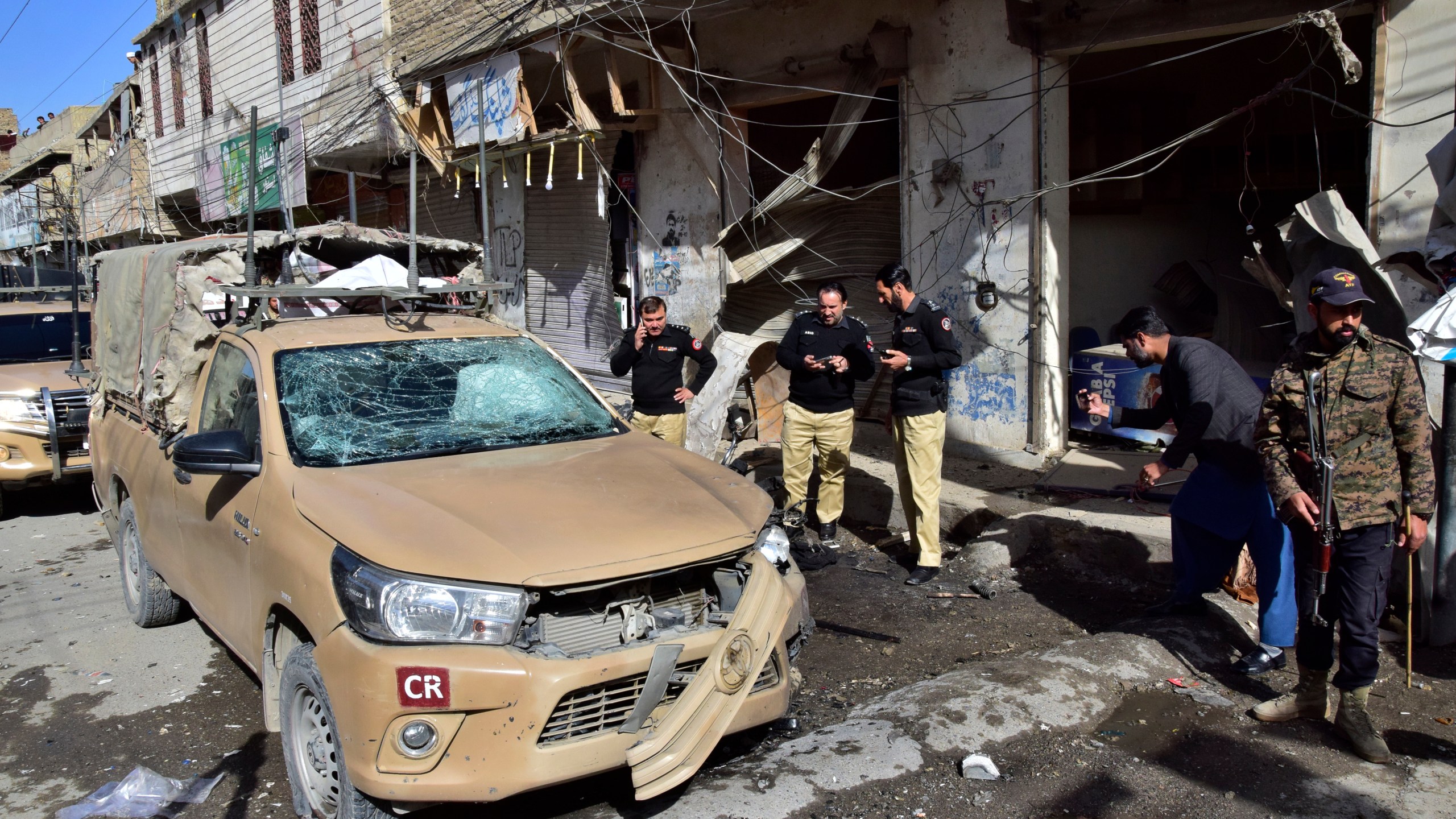 Security officials examine a damaged security forces' vehicle at the site of a bomb blast in Quetta, Pakistan, Friday, Feb. 28, 2025. (AP Photo/Arshad Butt)