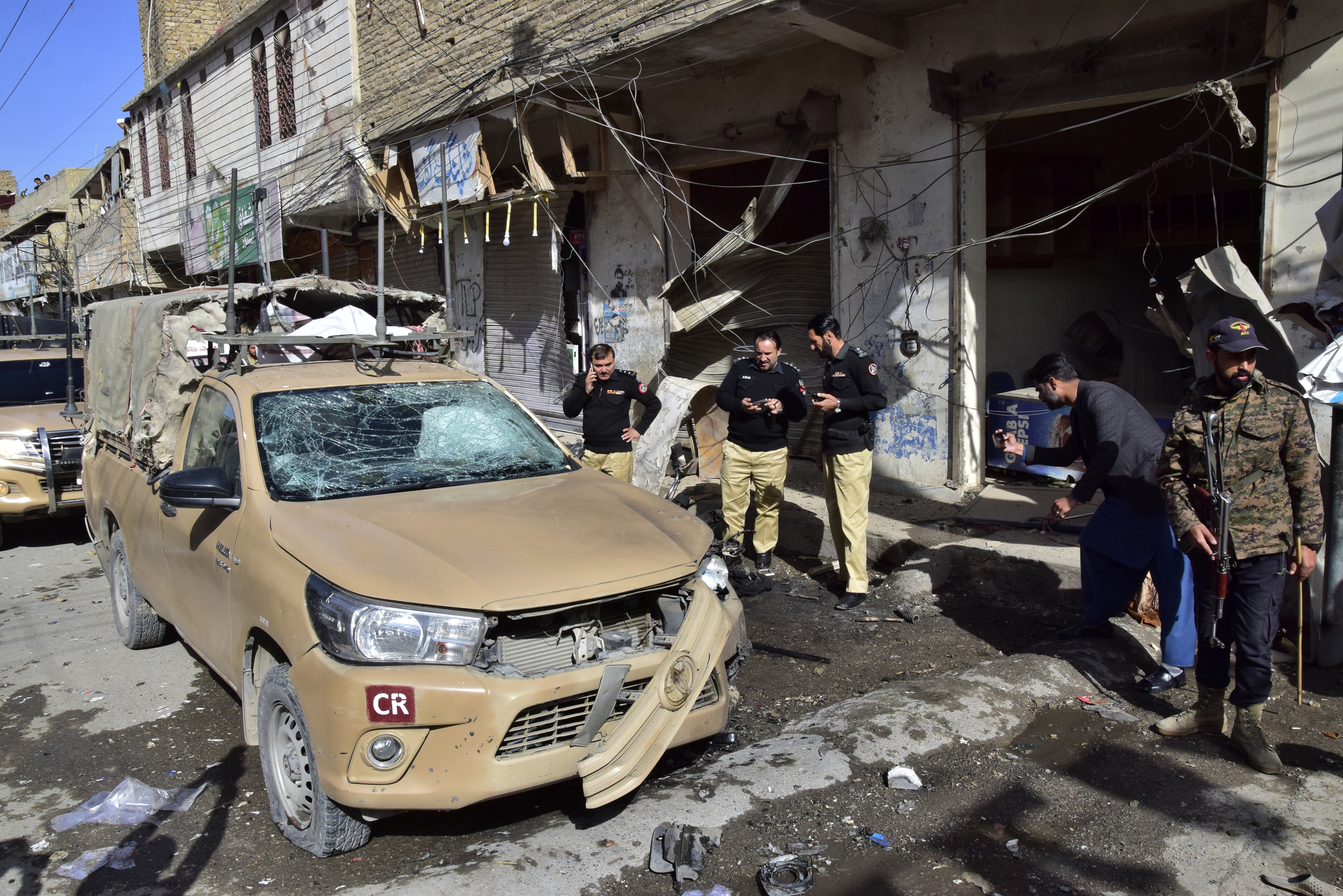 Security officials examine a damaged security forces' vehicle at the site of a bomb blast in Quetta, Pakistan, Friday, Feb. 28, 2025. (AP Photo/Arshad Butt)