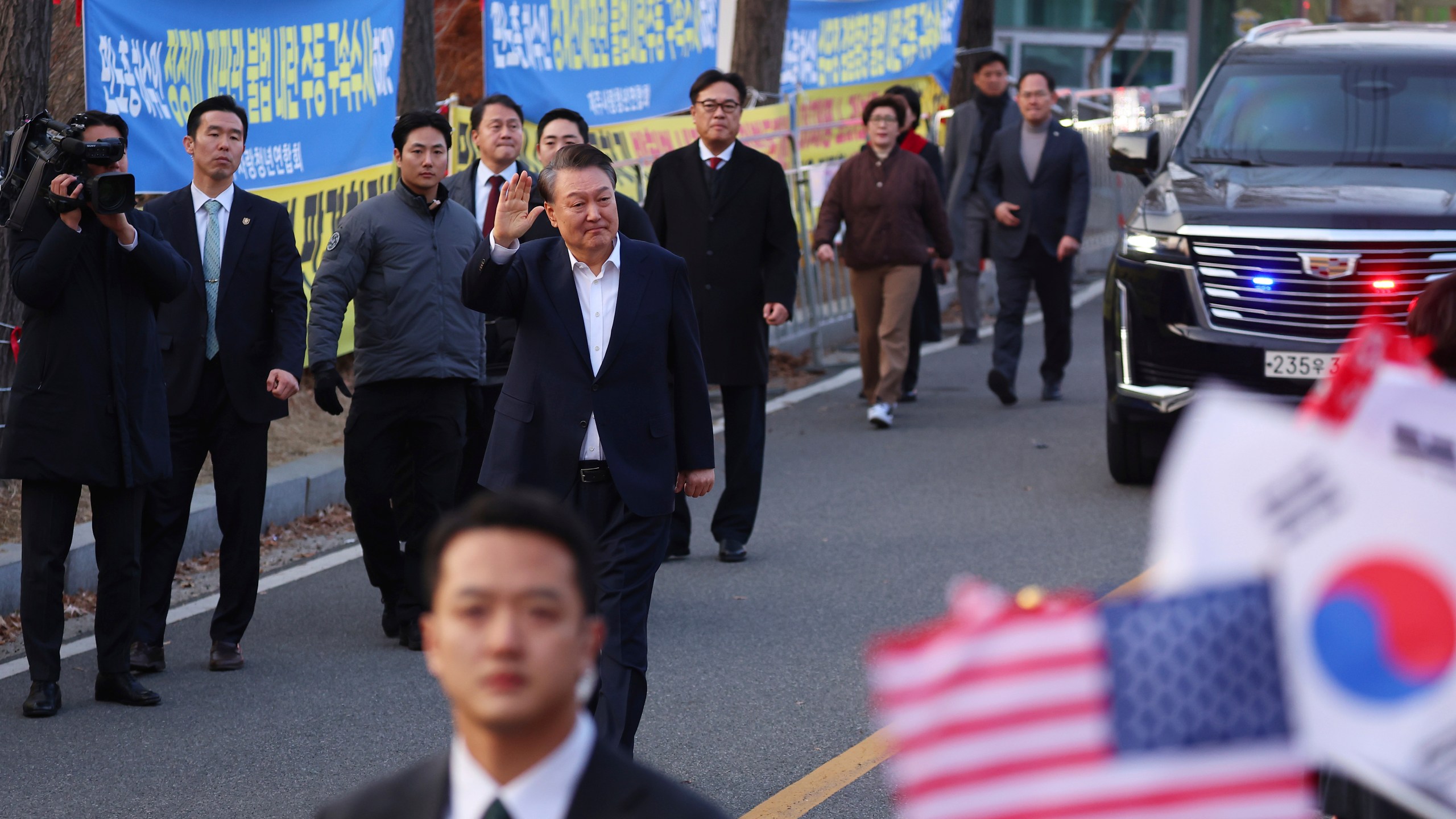 Impeached South Korean President Yoon Suk Yeol waves to his supporters after he came out of a detention center in Uiwang, South Korea, Saturday, March 8, 2025. (Kim Do-hun/Yonhap via AP)