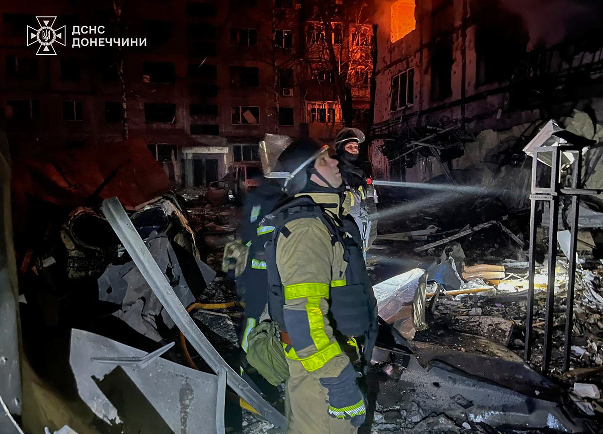 In this photo provided by the Ukrainian Emergency Service, firefighters put out the fire following a Russian rocket attack in Dobropillya, Donetsk region, Ukraine, Saturday, March 8, 2025. (Ukrainian Emergency Service via AP)