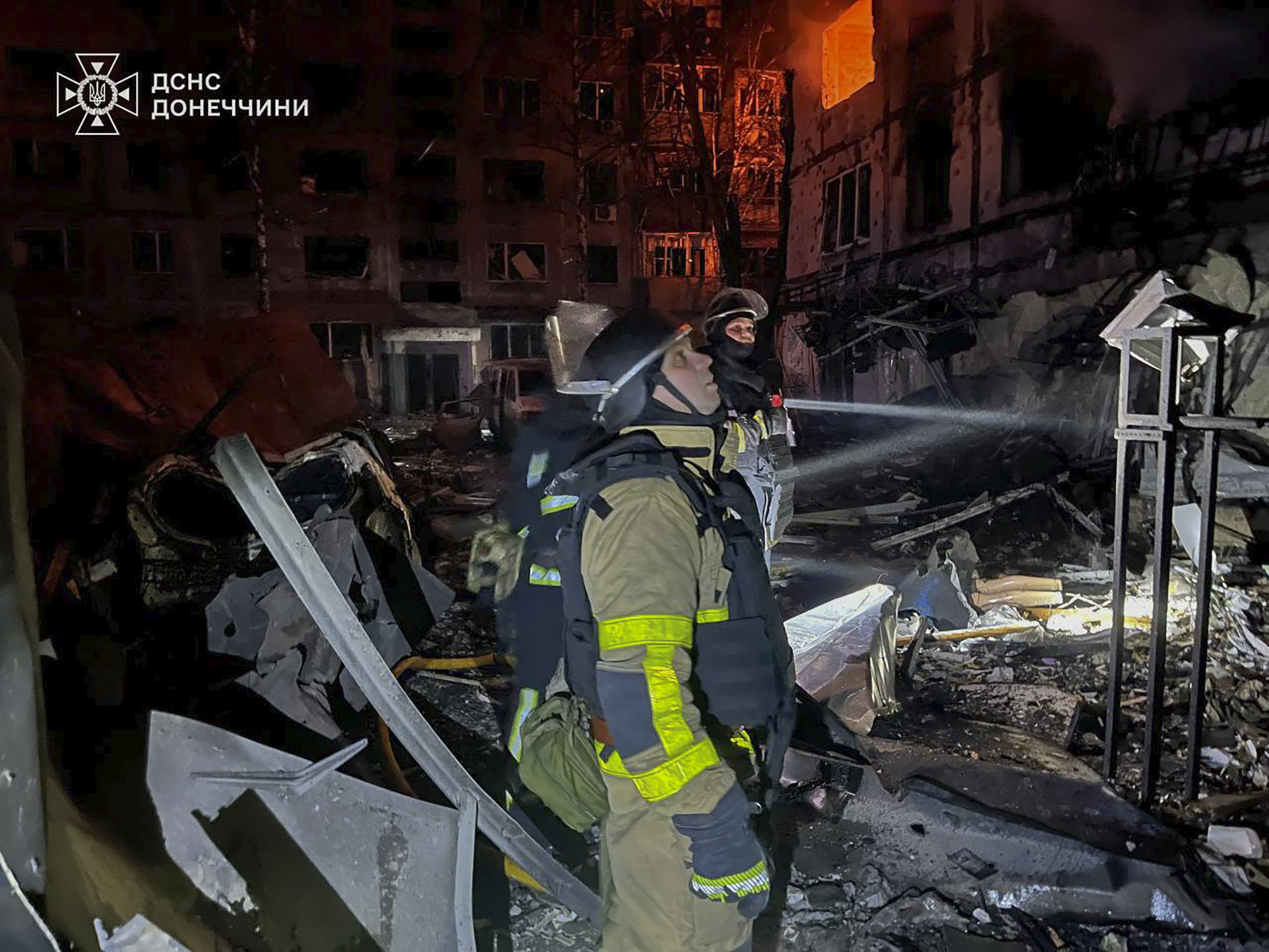 In this photo provided by the Ukrainian Emergency Service, firefighters put out the fire following a Russian rocket attack in Dobropillya, Donetsk region, Ukraine, Saturday, March 8, 2025. (Ukrainian Emergency Service via AP)