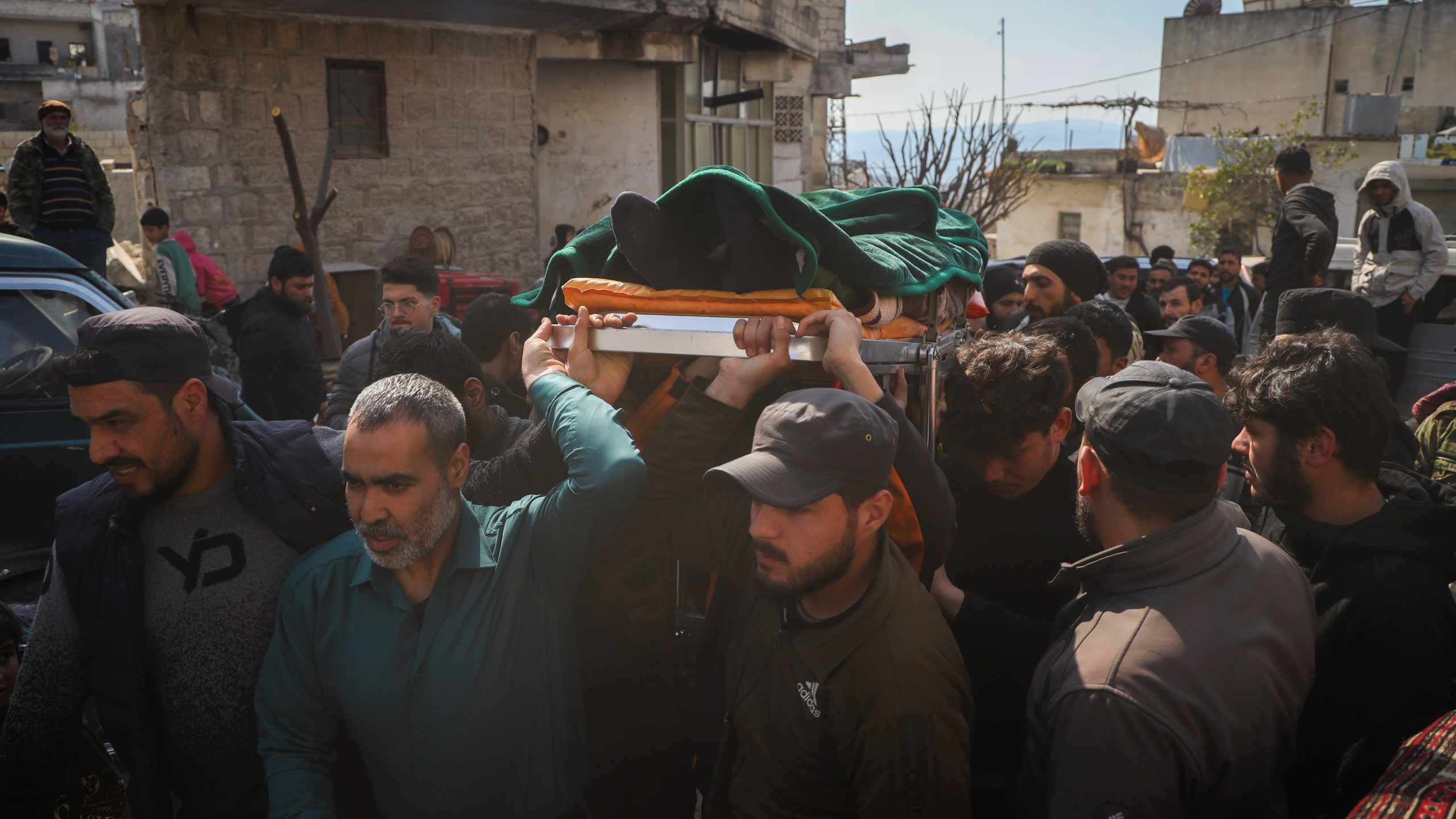 The body of a Syrian security force member killed in clashes with loyalists of ousted President Bashar Assad in coastal Syria, is carried for burial in the village of Al-Janoudiya, west of Idlib, Saturday, March 8, 2025. (AP Photo/Omar Albam)