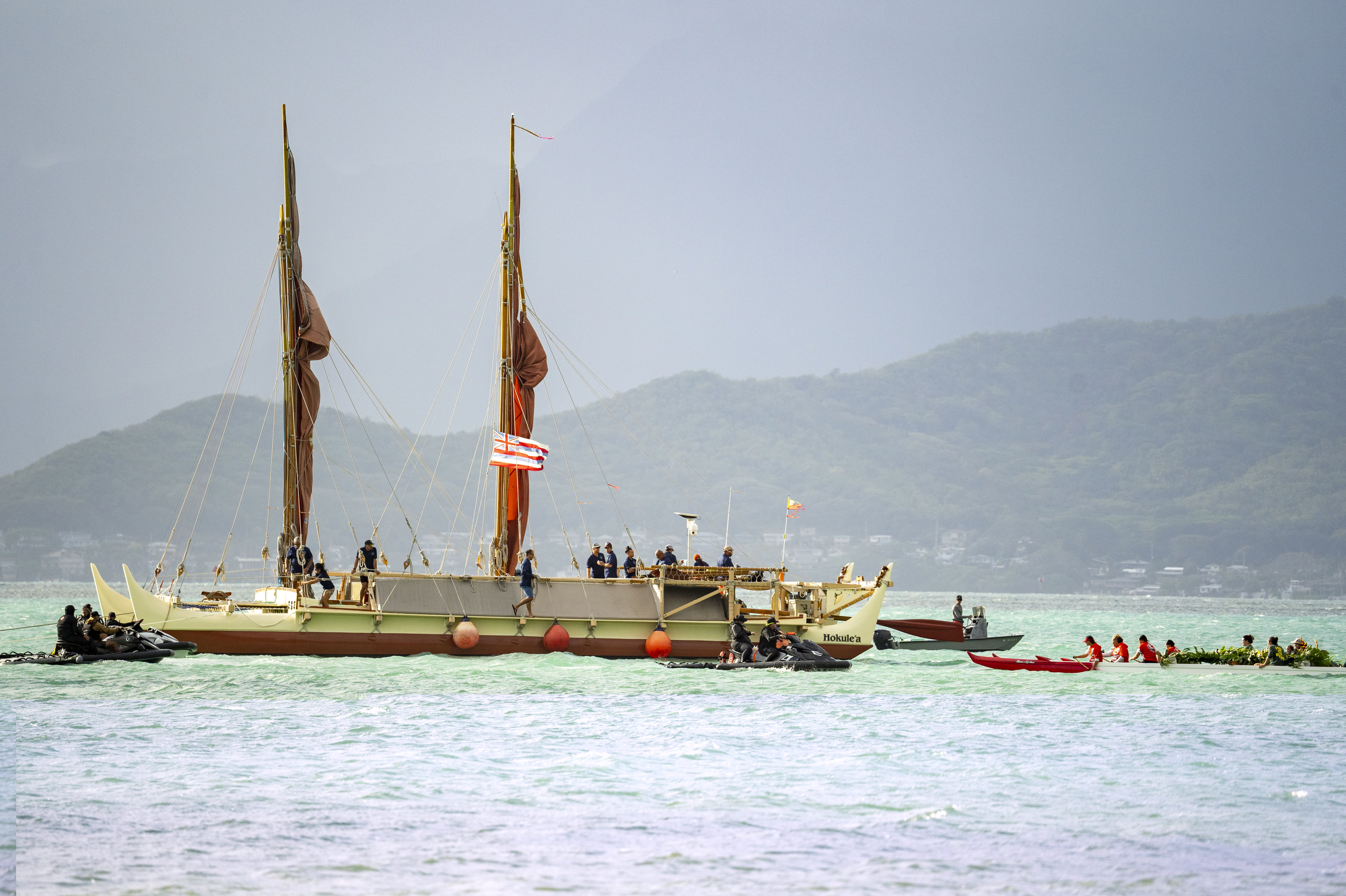 Kaneohe canoe club welcomes Hokulea as it arrives the shore of Kualoa Regional Park before Hokulea's 50th birthday commemoration, Saturday, March 8, 2025, in Kaneohe, Hawaii. (AP Photo/Mengshin Lin)