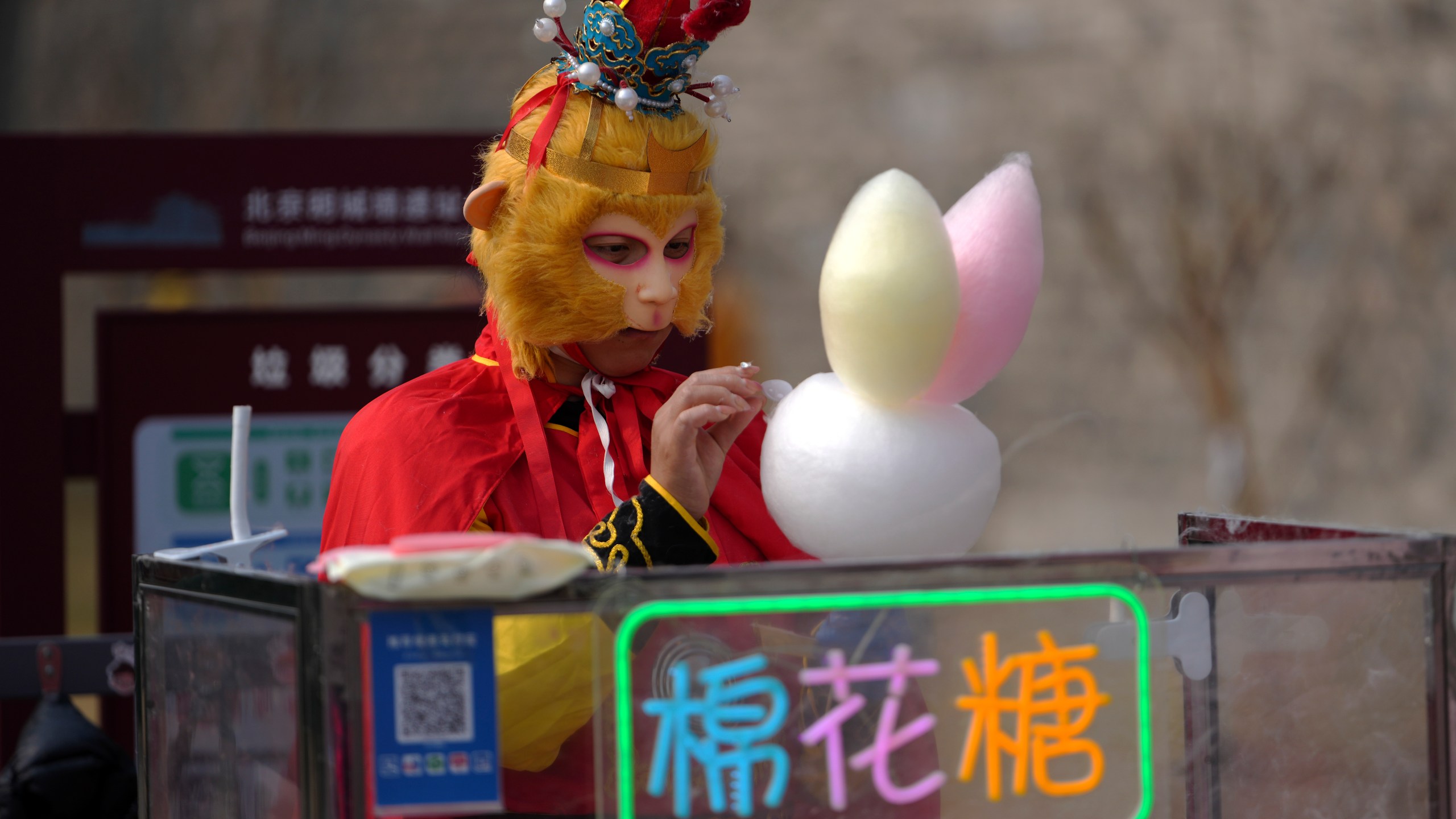 A vendor dressed with Monkey King costume sells cotton candy at the Chongwenmen Gate in Beijing, Sunday, March 9, 2025. (AP Photo/Andy Wong)