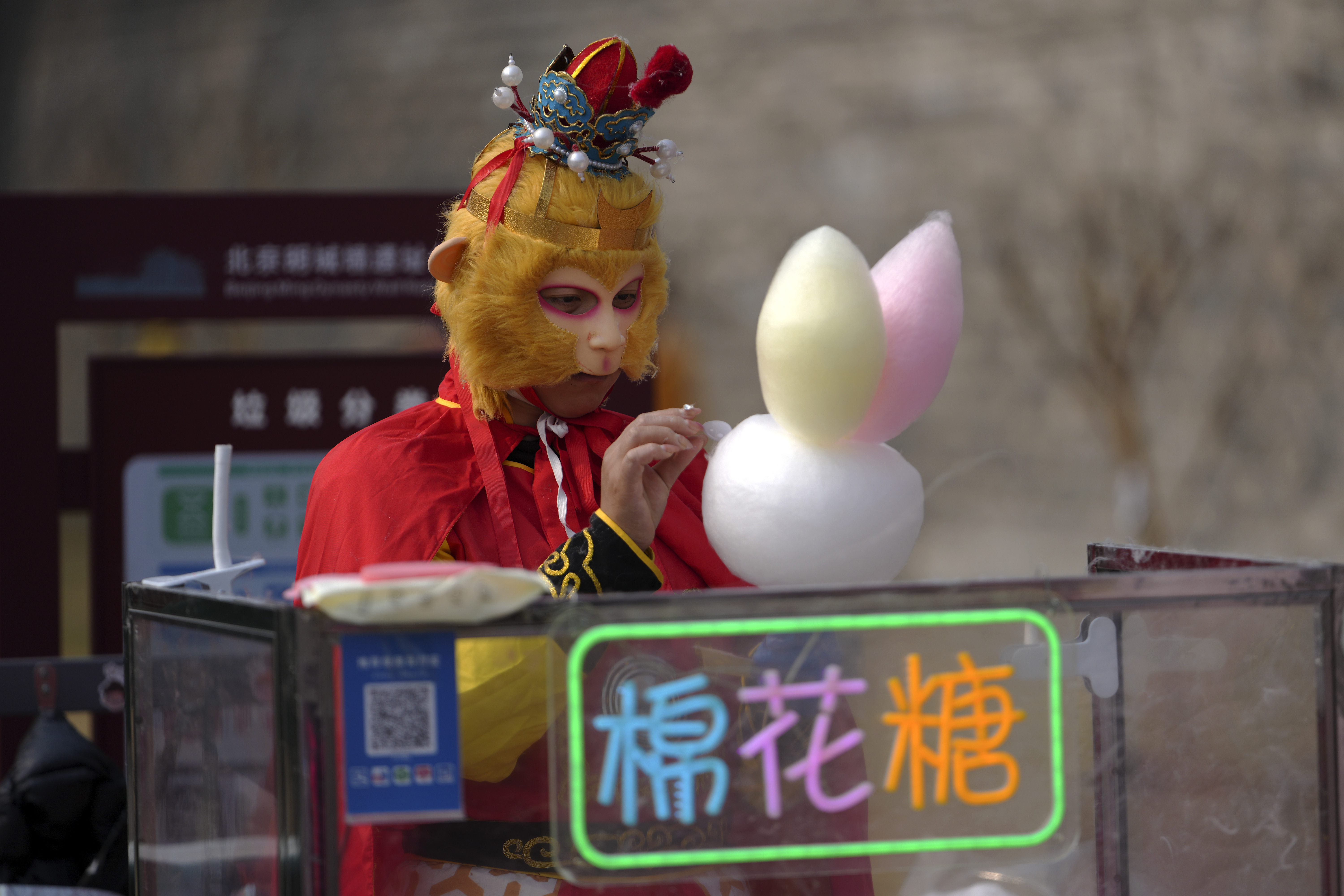 A vendor dressed with Monkey King costume sells cotton candy at the Chongwenmen Gate in Beijing, Sunday, March 9, 2025. (AP Photo/Andy Wong)