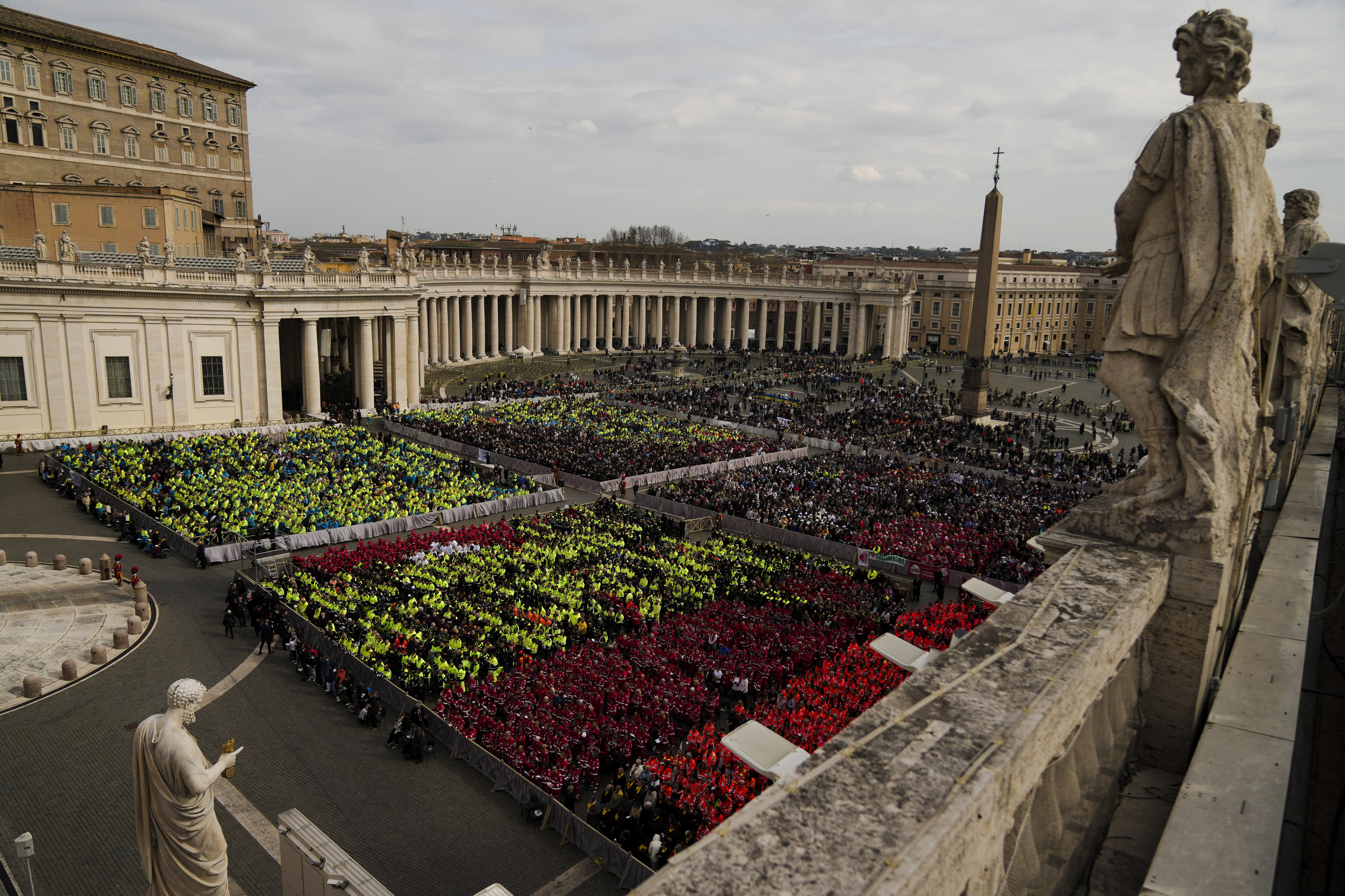 Members of different organizations of volunteers follow Cardinal Michael Czerny, delegate of Pope Francis who is being treated for pneumonia at Rome's Agostino Gemelli Polyclinic, celebrating a mass for the world of volunteers in St. Peter's Square at The Vatican, Sunday, March 9, 2025. (AP Photo/Francisco Seco)