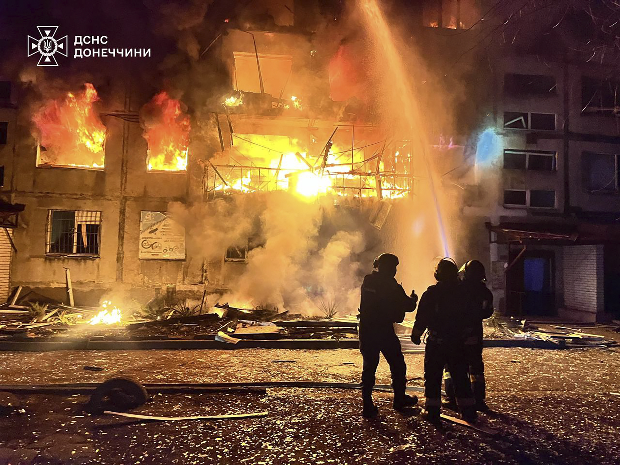 In this photo provided by the Ukrainian Emergency Service, firefighters put out the fire following a Russian rocket attack in Dobropillya, Donetsk region, Ukraine, Saturday, March 8, 2025. (Ukrainian Emergency Service via AP)