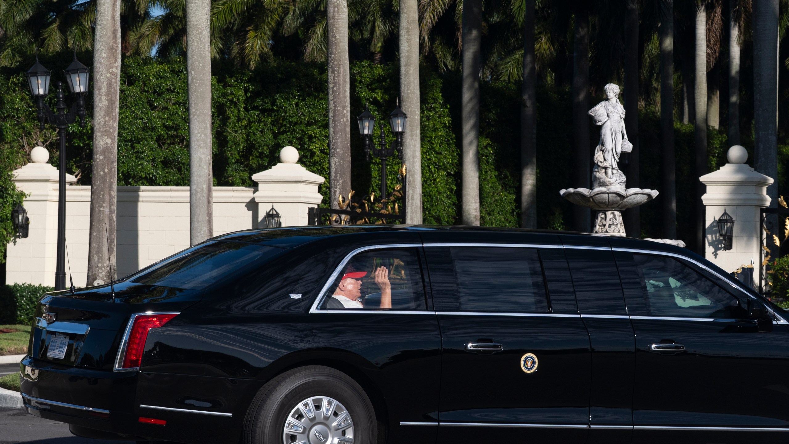 President Donald Trump waves from his limousine as he arrives at his golf club in West Palm Beach, Fla., Saturday, March 8, 2025, in West Palm Beach, Fla. (AP Photo/Manuel Balce Ceneta)