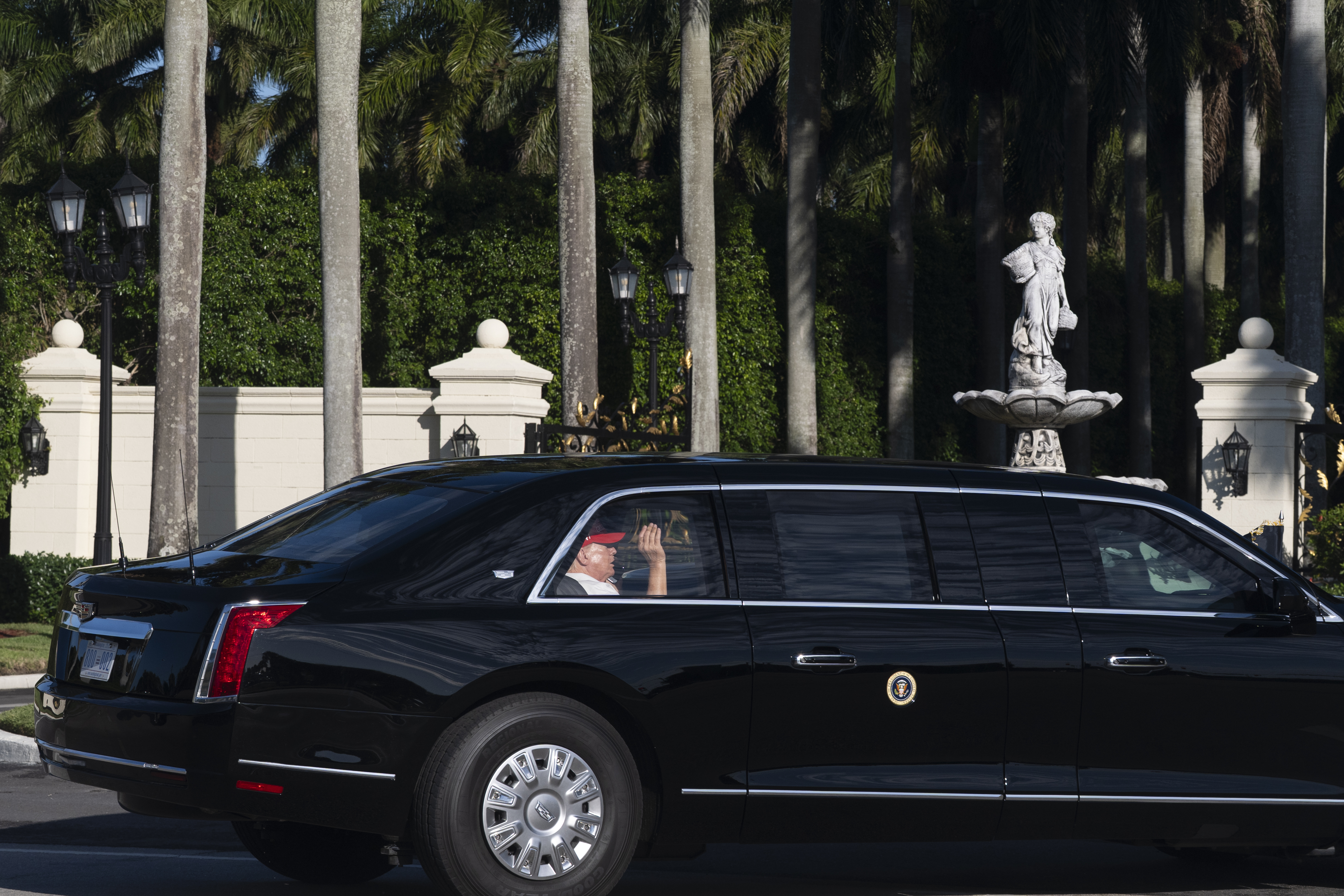 President Donald Trump waves from his limousine as he arrives at his golf club in West Palm Beach, Fla., Saturday, March 8, 2025, in West Palm Beach, Fla. (AP Photo/Manuel Balce Ceneta)