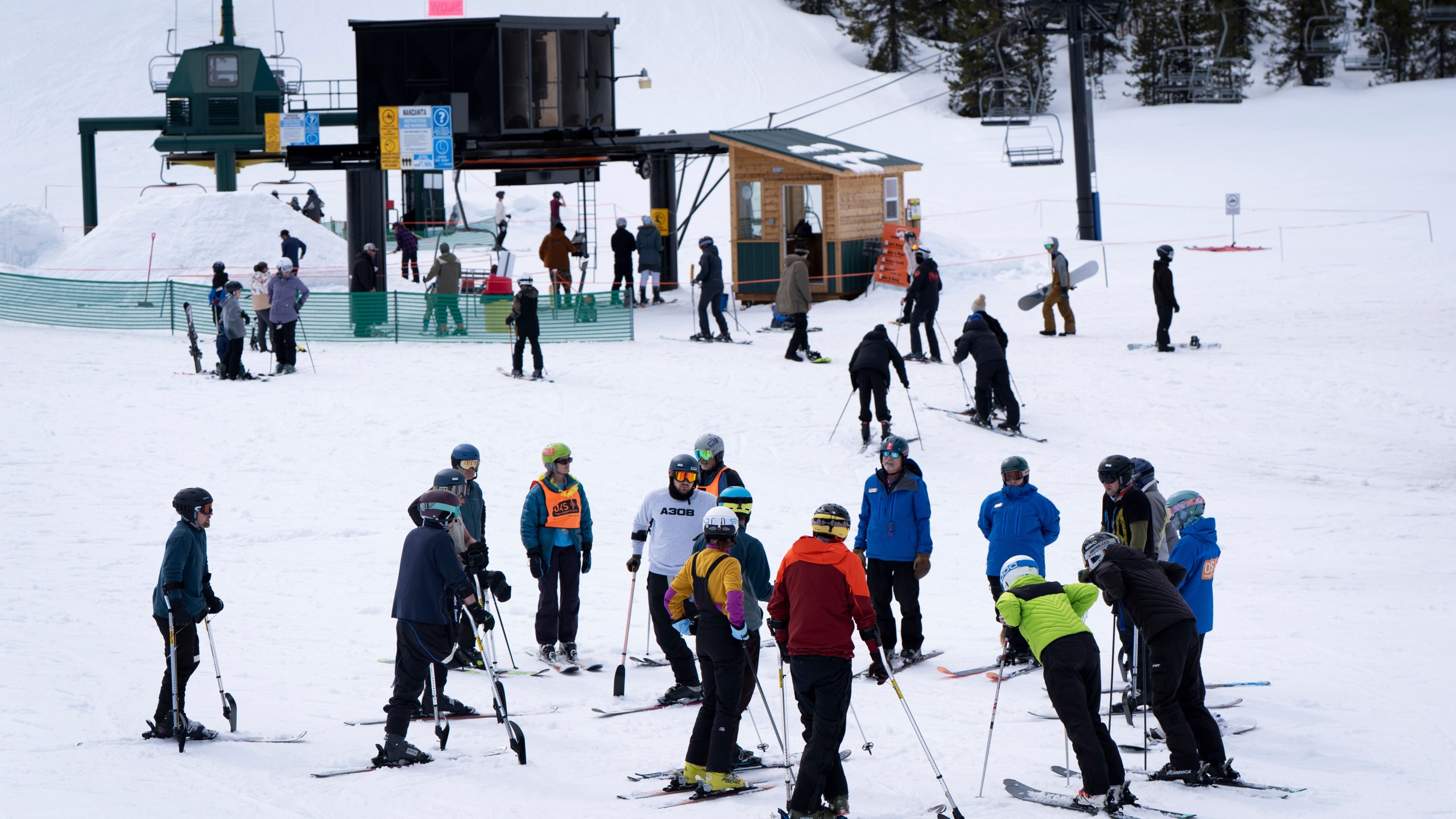 Ukrainian veterans and ski instructors talk before going on a chair lift during a lesson with Oregon Adaptive Sports on the three track skiing method at Hoodoo Ski Area in central Oregon on Thursday, March 6, 2025. (AP Photo/Jenny Kane)