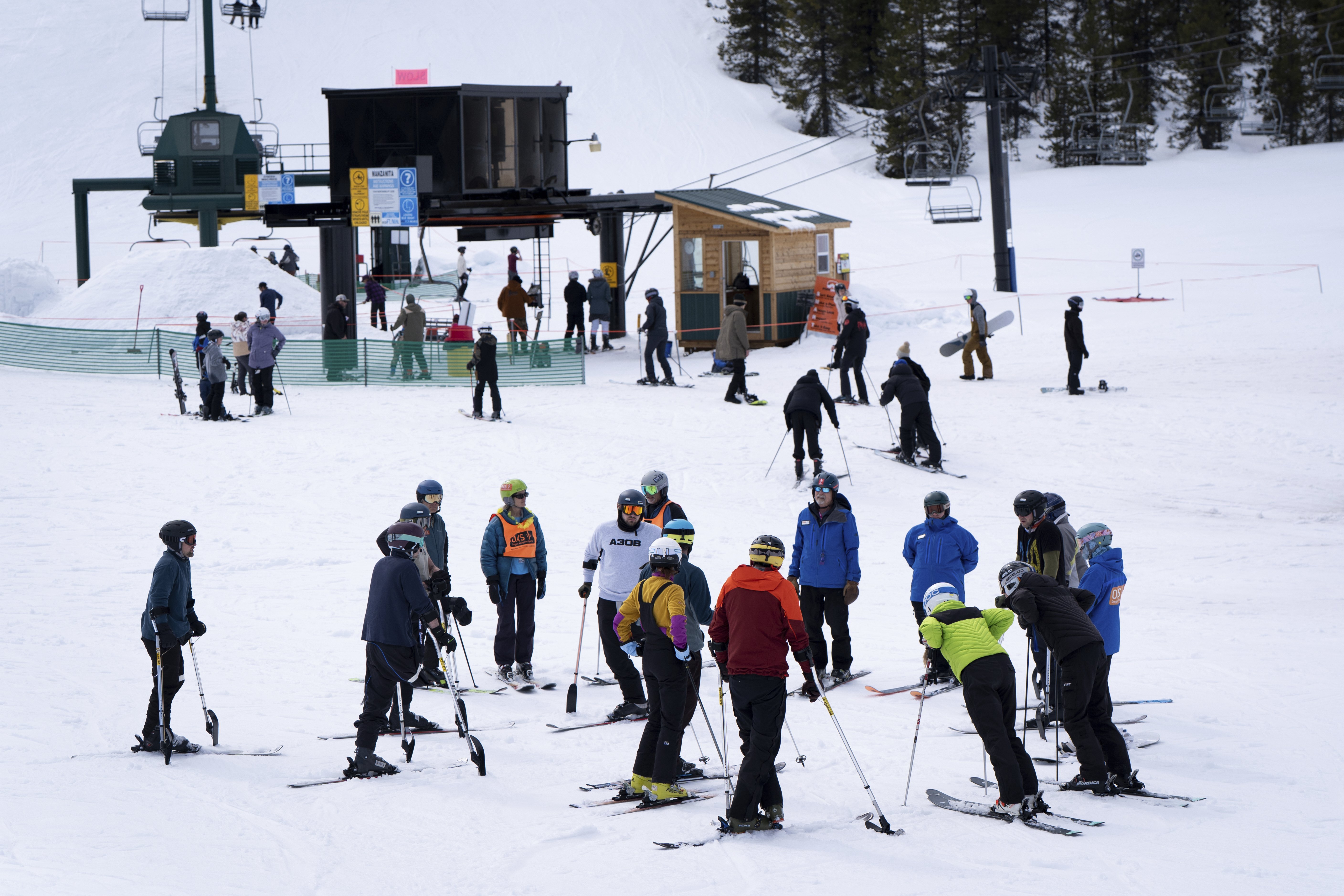 Ukrainian veterans and ski instructors talk before going on a chair lift during a lesson with Oregon Adaptive Sports on the three track skiing method at Hoodoo Ski Area in central Oregon on Thursday, March 6, 2025. (AP Photo/Jenny Kane)