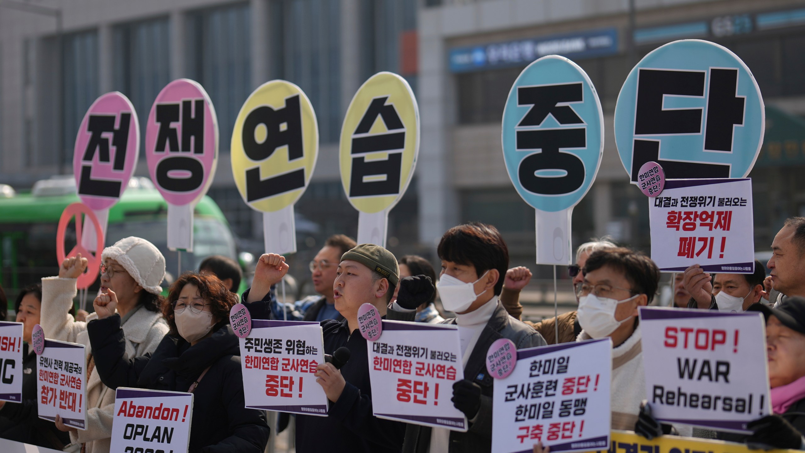 Protesters shout slogans during a press conference demanding to stop the upcoming Freedom Shield military exercise between the U.S. and South Korea, near the Defense Ministry in Seoul, South Korea, Monday, March 10, 2025. The letters read "Stop, War exercise." (AP Photo/Lee Jin-man)