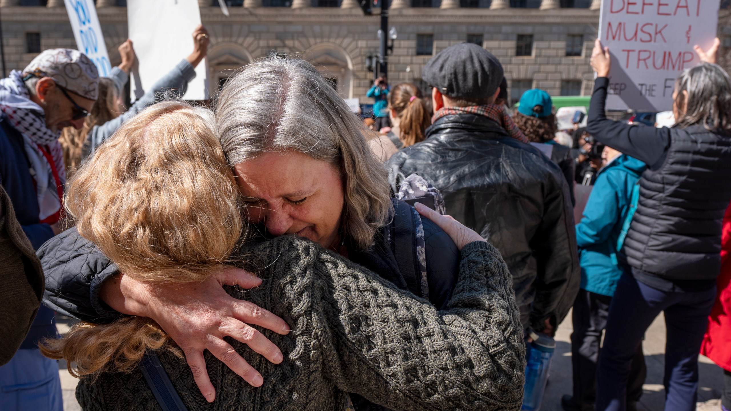 Lane Pollack, center, of Rockville, Md., a senior learning advisor at USAID for 14 years, is consoled by a co-worker after having 15 minutes to clear out her belongings from the USAID headquarters, Friday, Feb. 28, 2025, in Washington. (AP Photo/Jacquelyn Martin)