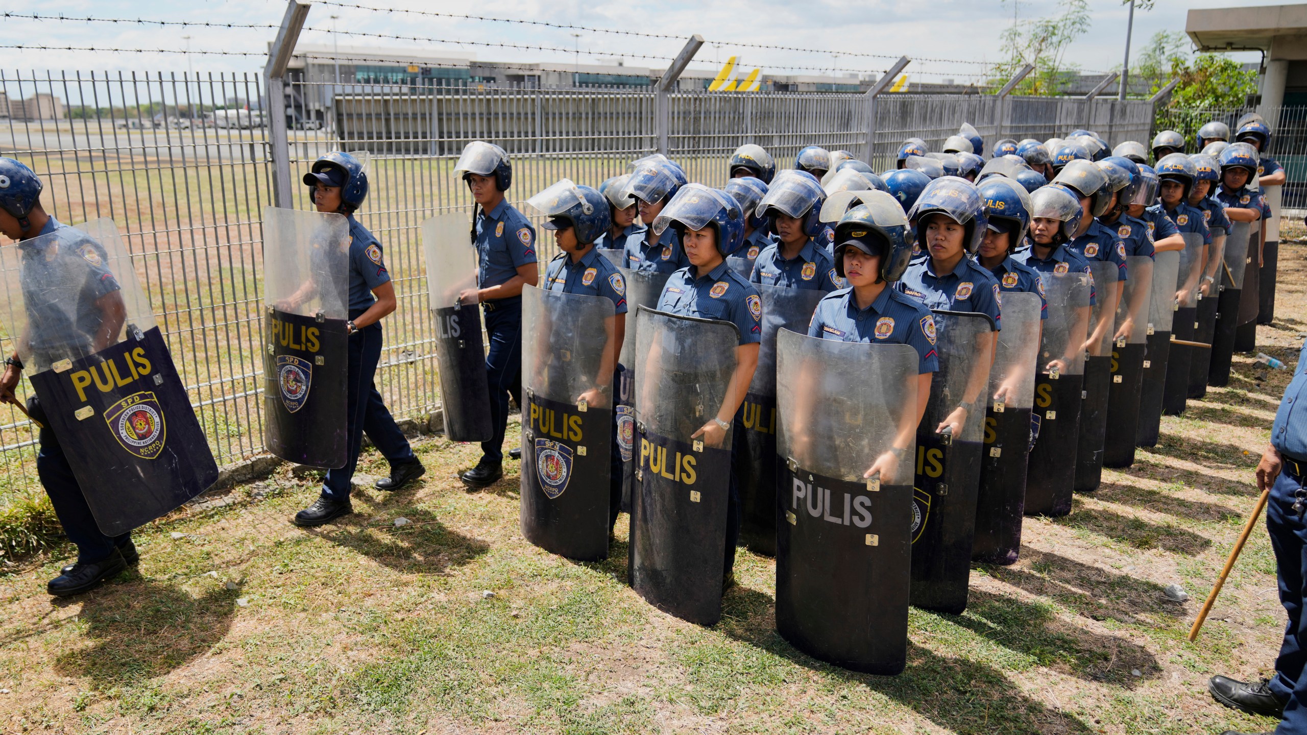 Security officials stand outside Villamor Air Base after former President Rodrigo Duterte was arrested, Tuesday, March 11, 2025, near Manila, Philippines. (AP Photo/Aaron Favila)