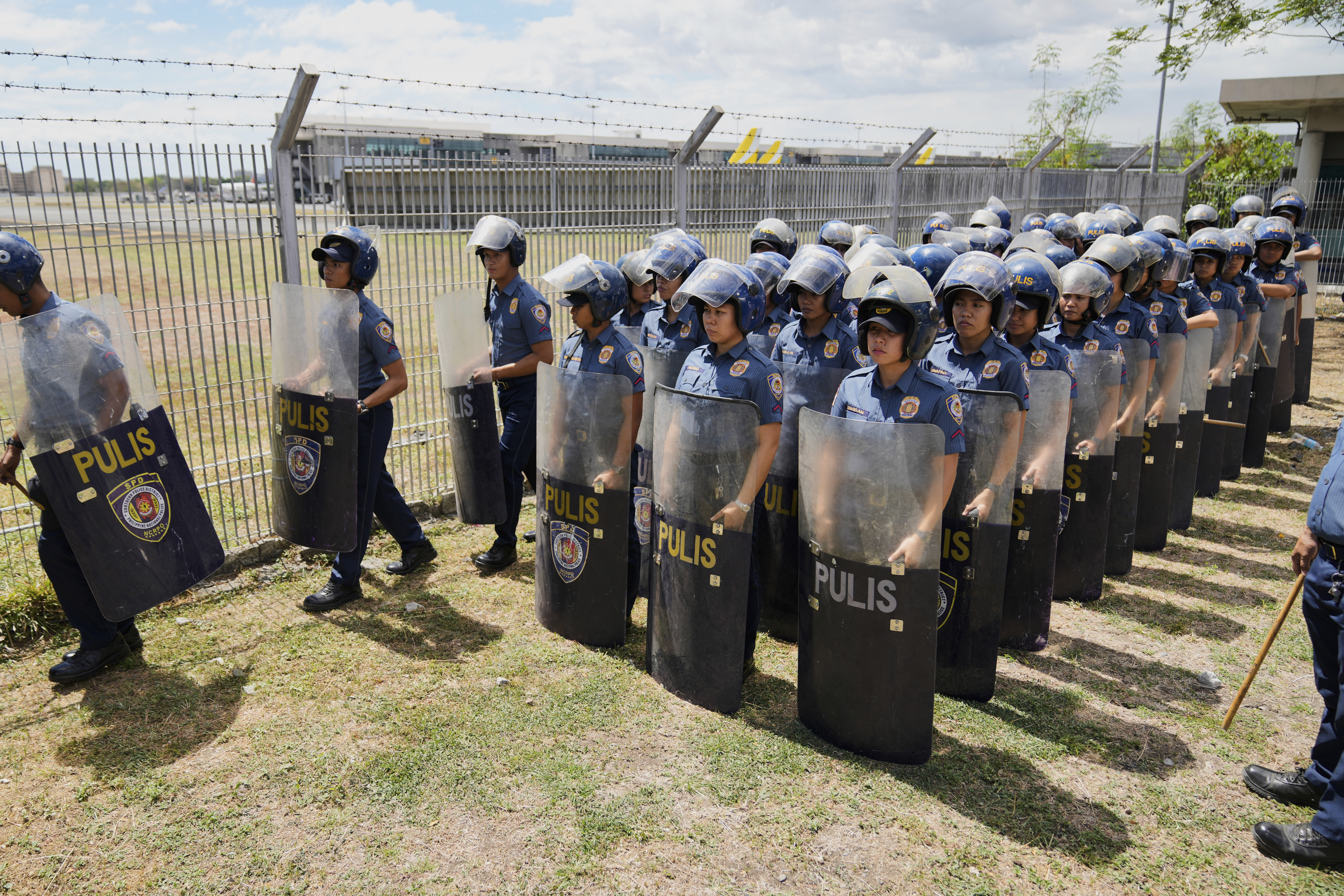 Security officials stand outside Villamor Air Base after former President Rodrigo Duterte was arrested, Tuesday, March 11, 2025, near Manila, Philippines. (AP Photo/Aaron Favila)