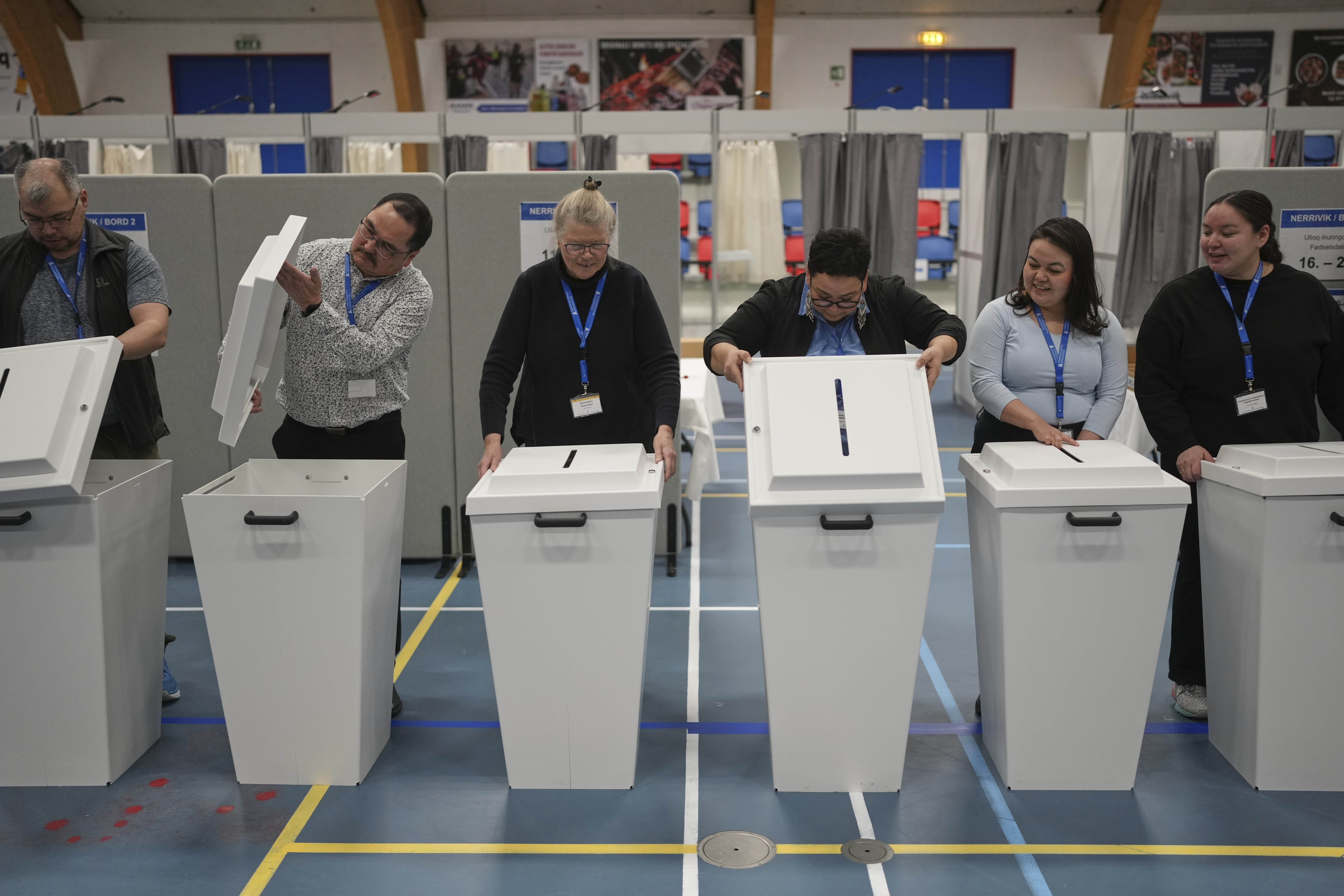 The election commission prepares ballot boxes for people to cast their vote in parliamentary elections, in Nuuk, Greenland, Tuesday, March 11, 2025. (AP Photo/Evgeniy Maloletka)