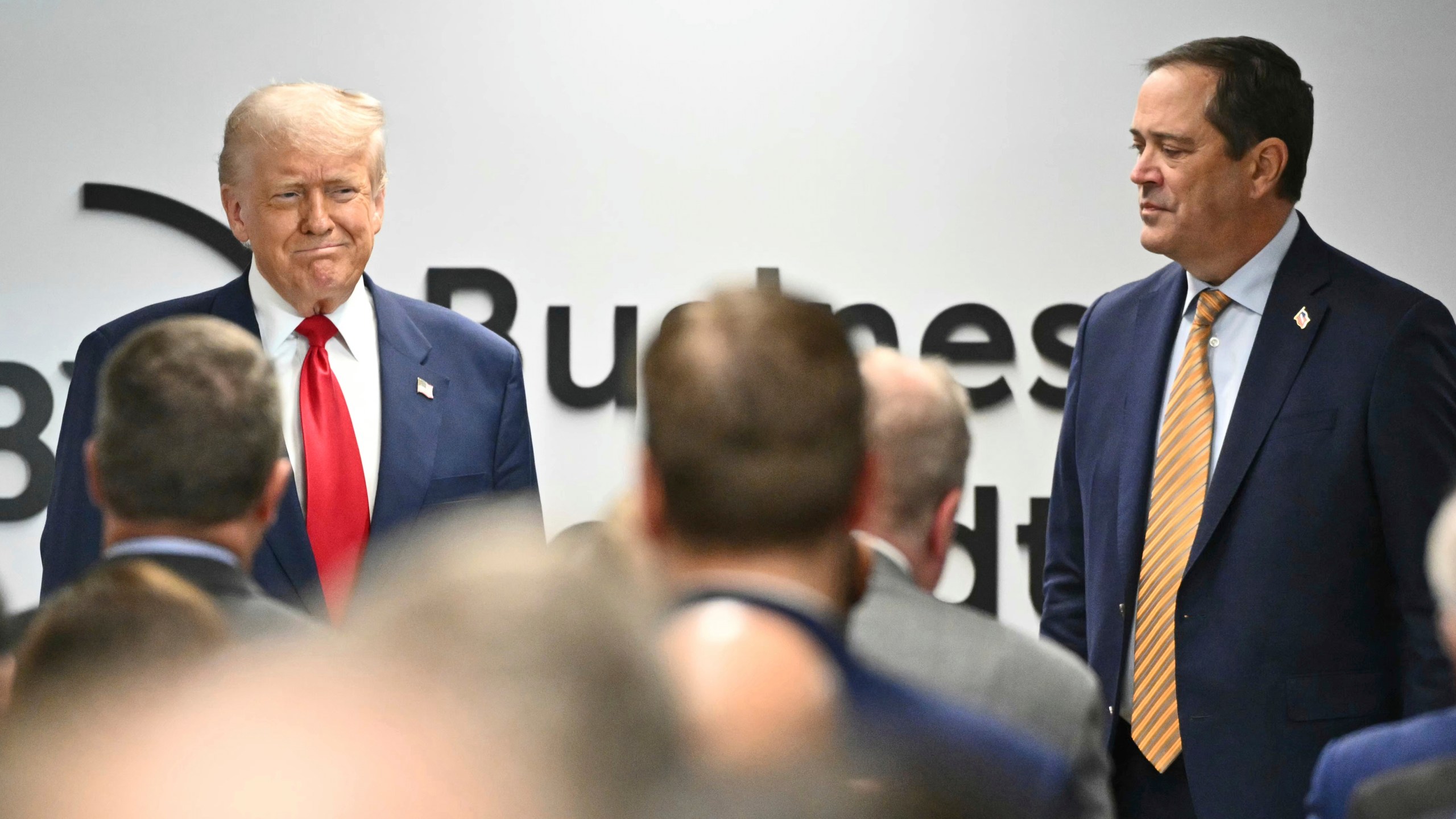 President Donald Trump arrives to speak at the Business Roundtable quarterly meeting in Washington, Tuesday, March 11, 2025, as Business Roundtable Chair and Cisco Chairman and CEO Chuck Robbins watches. (Pool via AP)