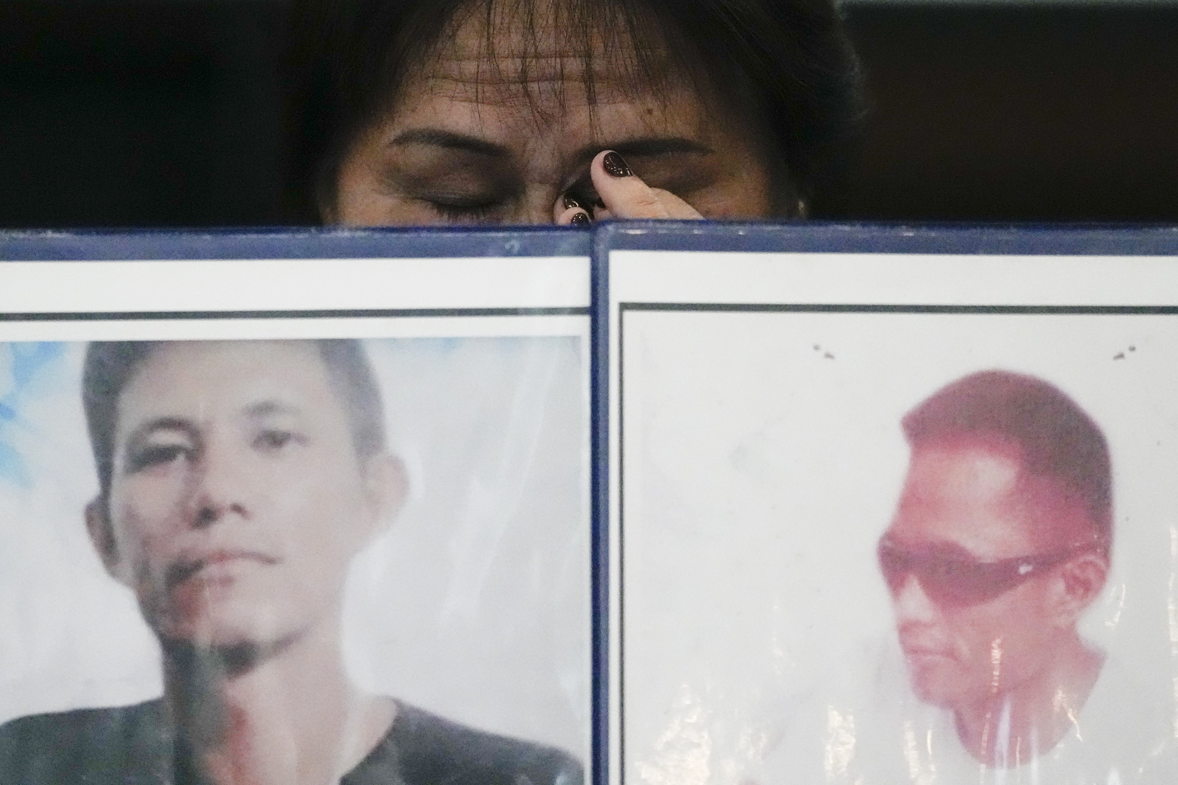 Llore Pasco wipes tears behind pictures of her sons who were victims of alleged extra-judicial killings as she attends a press conference a day after the arrest of former Philippine president Rodrigo Duterte in Quezon City, Philippines on Wednesday, March 12, 2025. (AP Photo/Aaron Favila)