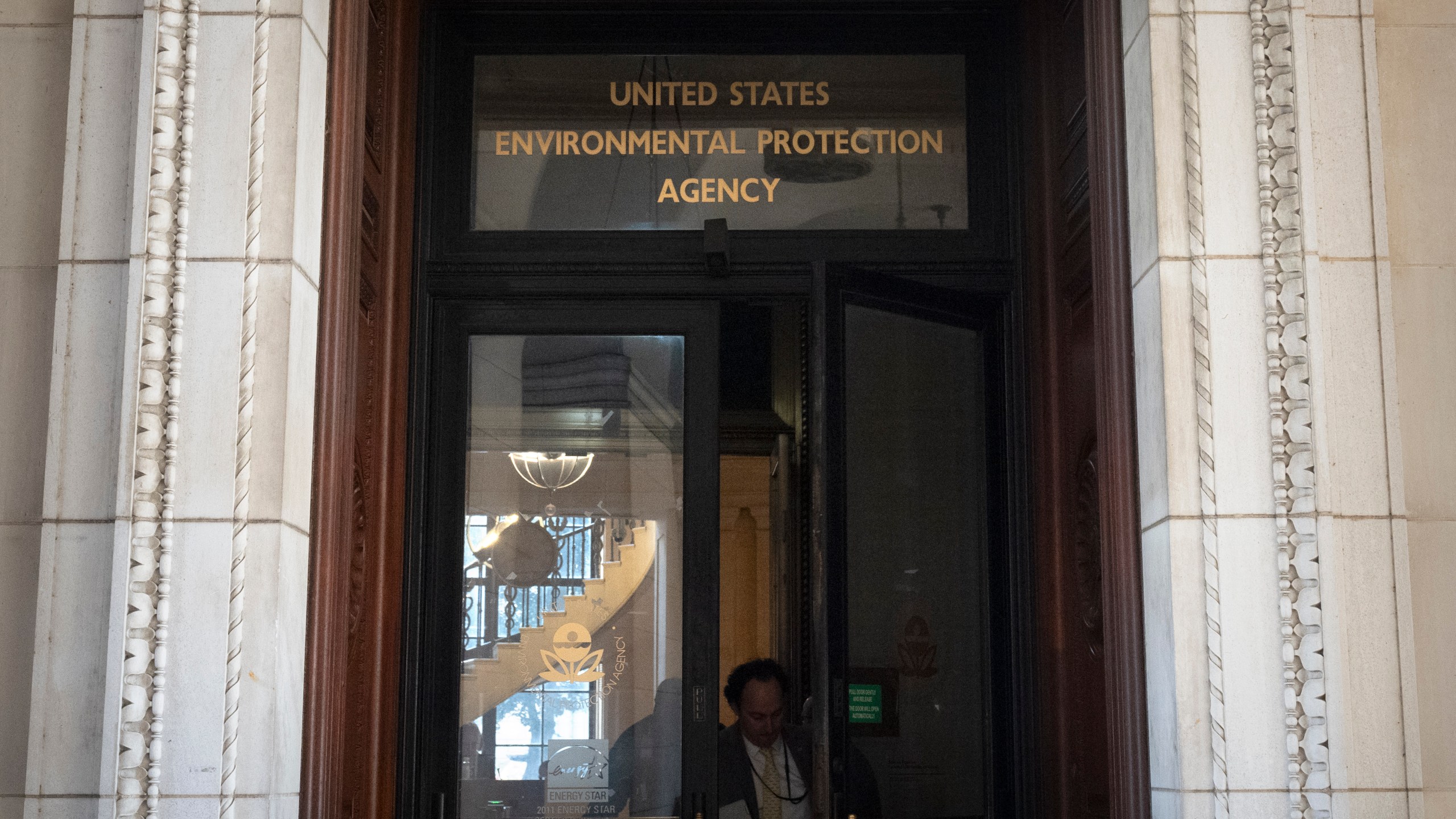 A person exits the headquarters building of the Environmental Protection Agency Wednesday, March 12, 2025, in Washington. (AP Photo/Mark Schiefelbein)