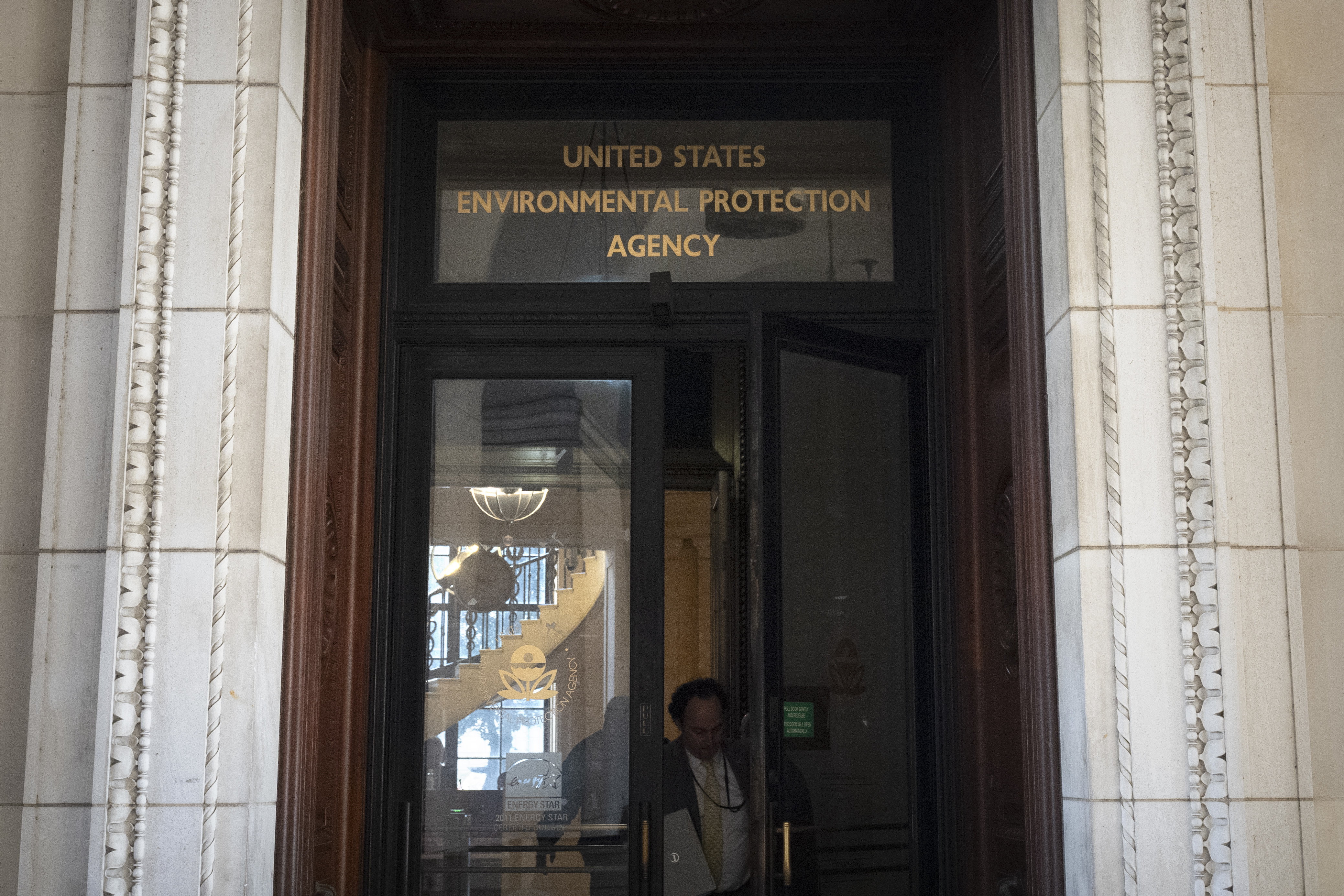 A person exits the headquarters building of the Environmental Protection Agency Wednesday, March 12, 2025, in Washington. (AP Photo/Mark Schiefelbein)