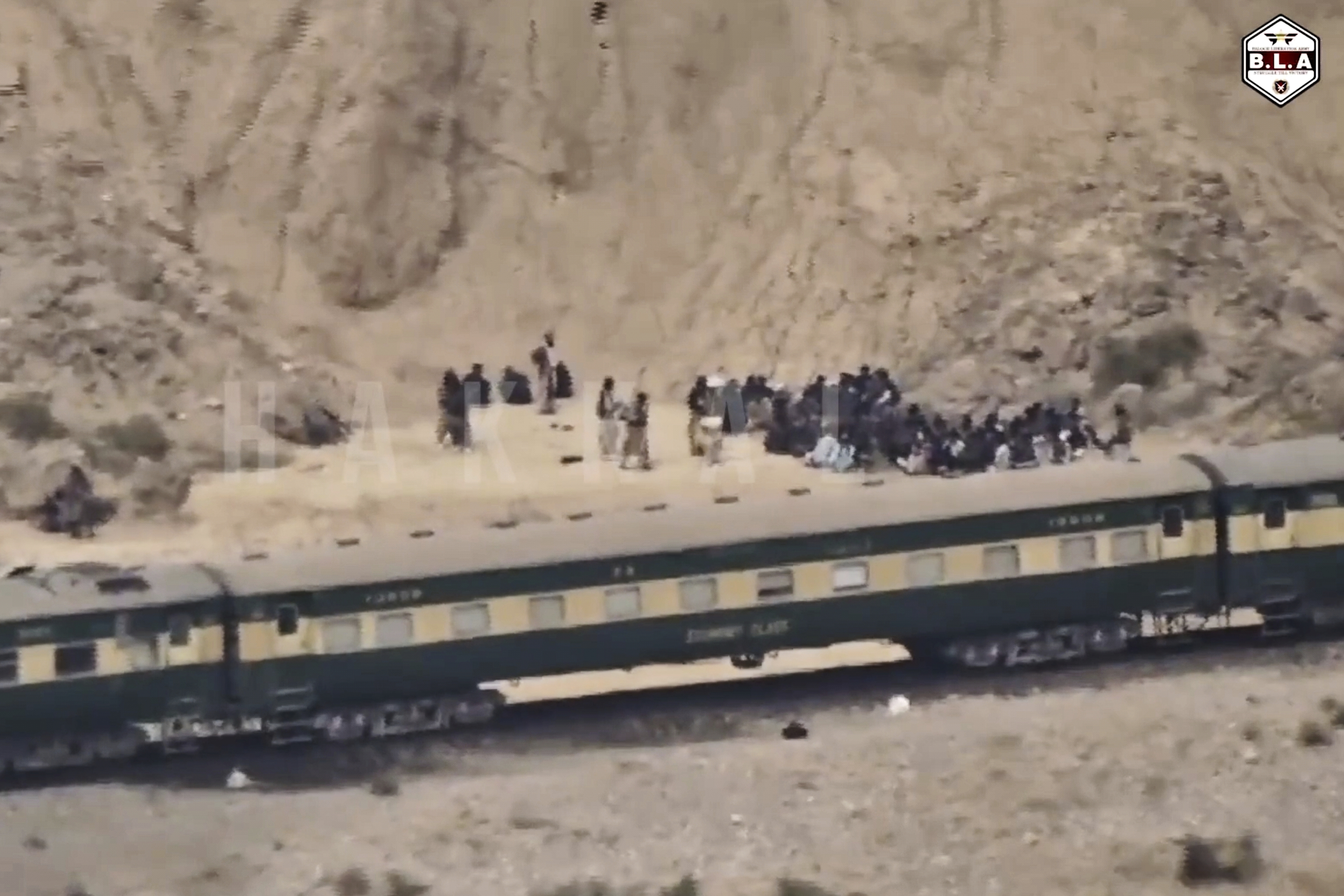 In this frame grab from a video released by the Baluchistan Liberation Army shows people outside the a train after being attacked by the BLA on its transit from Quetta to the northern city of Peshawar, in Bolan district, Pakistan's southwestern Balochistan province, March 12, 2025..(BLA via AP)