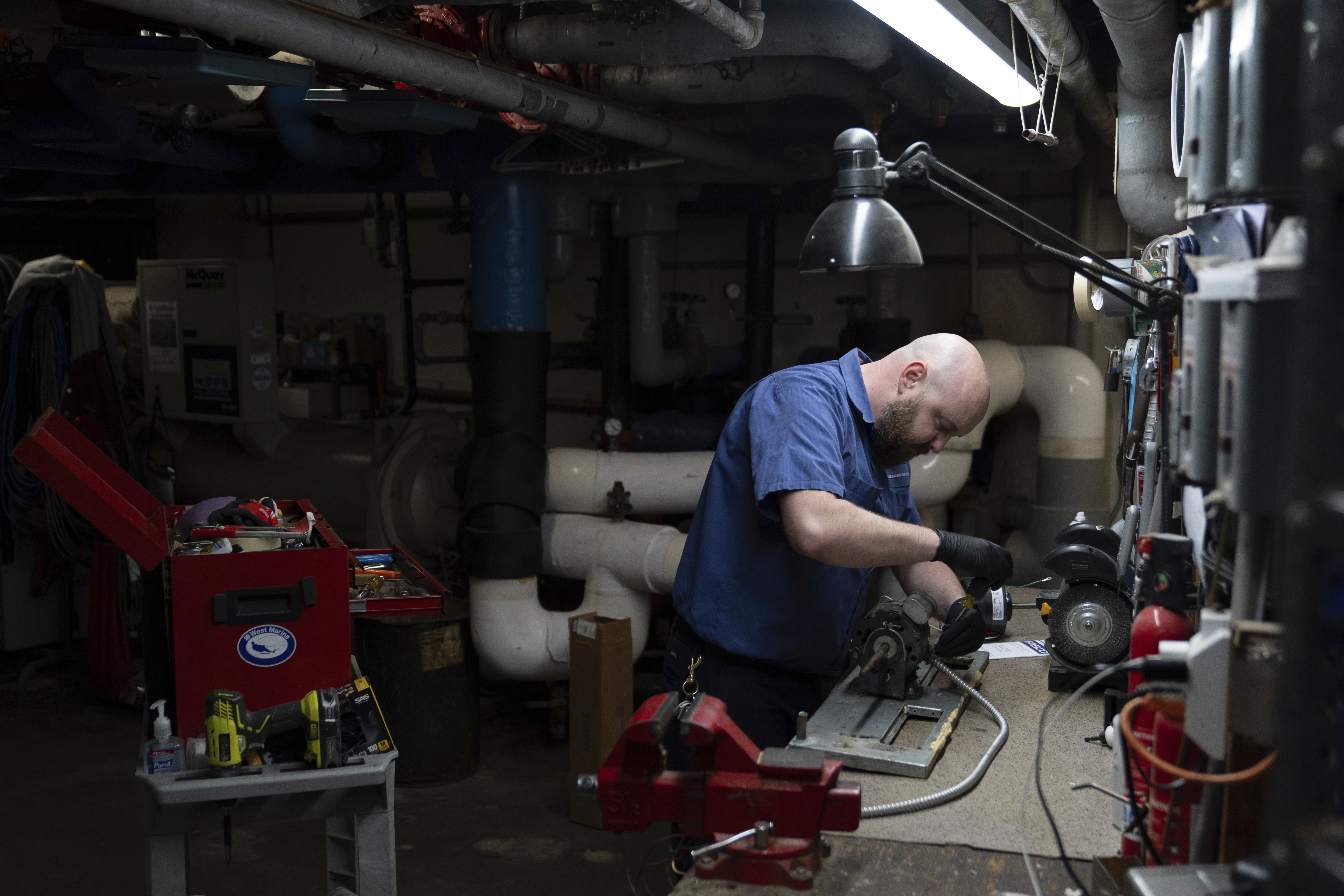 James Richardson works on a heating and cooling unit in the broiler room at Smith Tower Apartments in Vancouver, Wash., on Monday, March 10, 2025. (AP Photo/Jenny Kane)